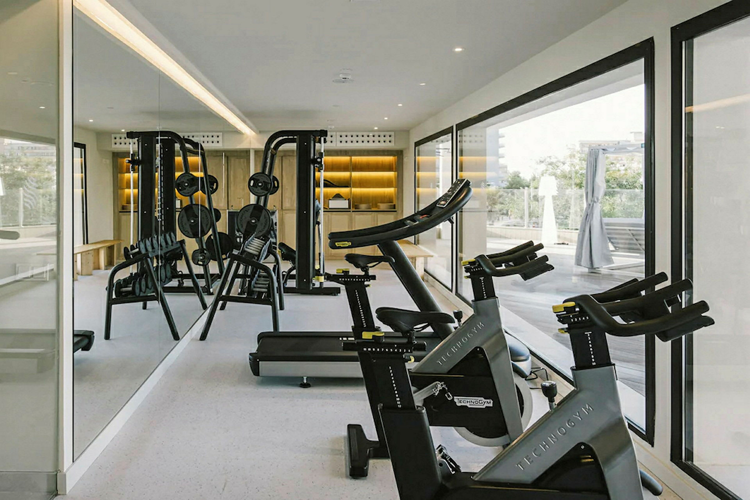 Ett gym med träningsutrustning som motionscyklar och vikthylla. (AI-genererad text)