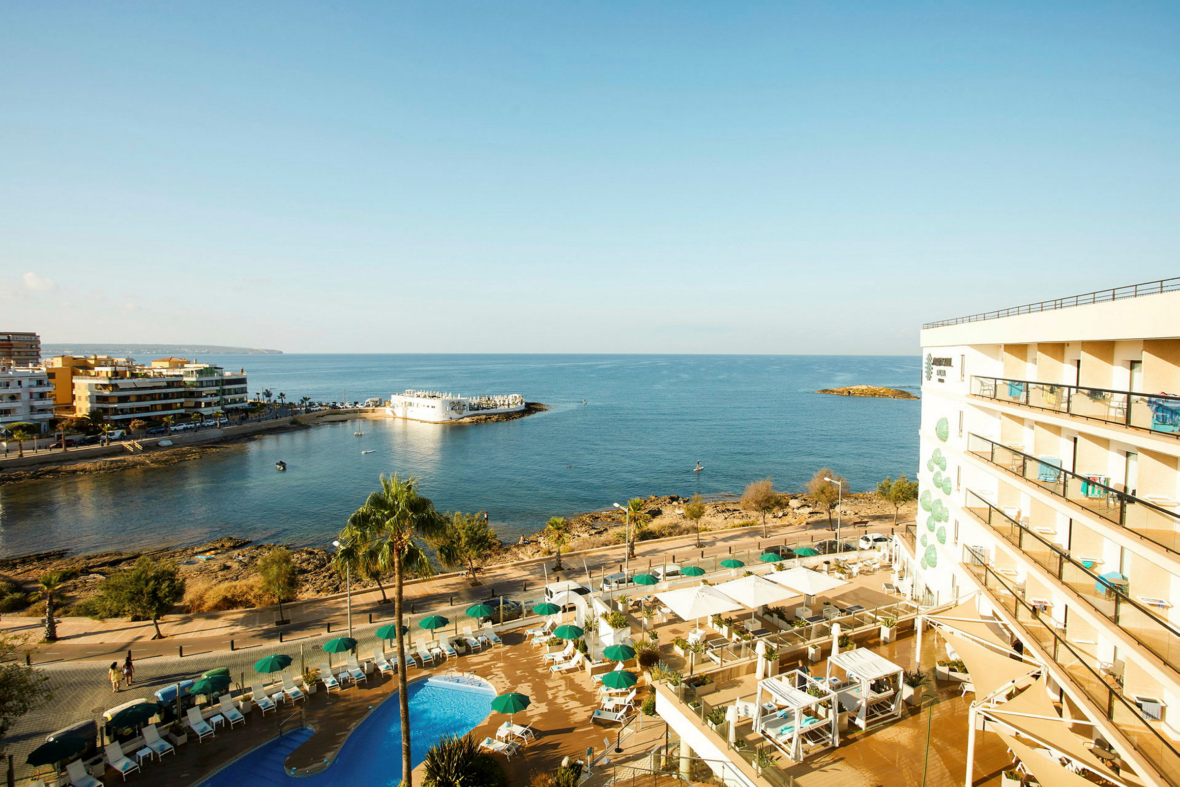 Hotellet med pooler och utsikt över havet och kustlinjen. (AI-genererad text)