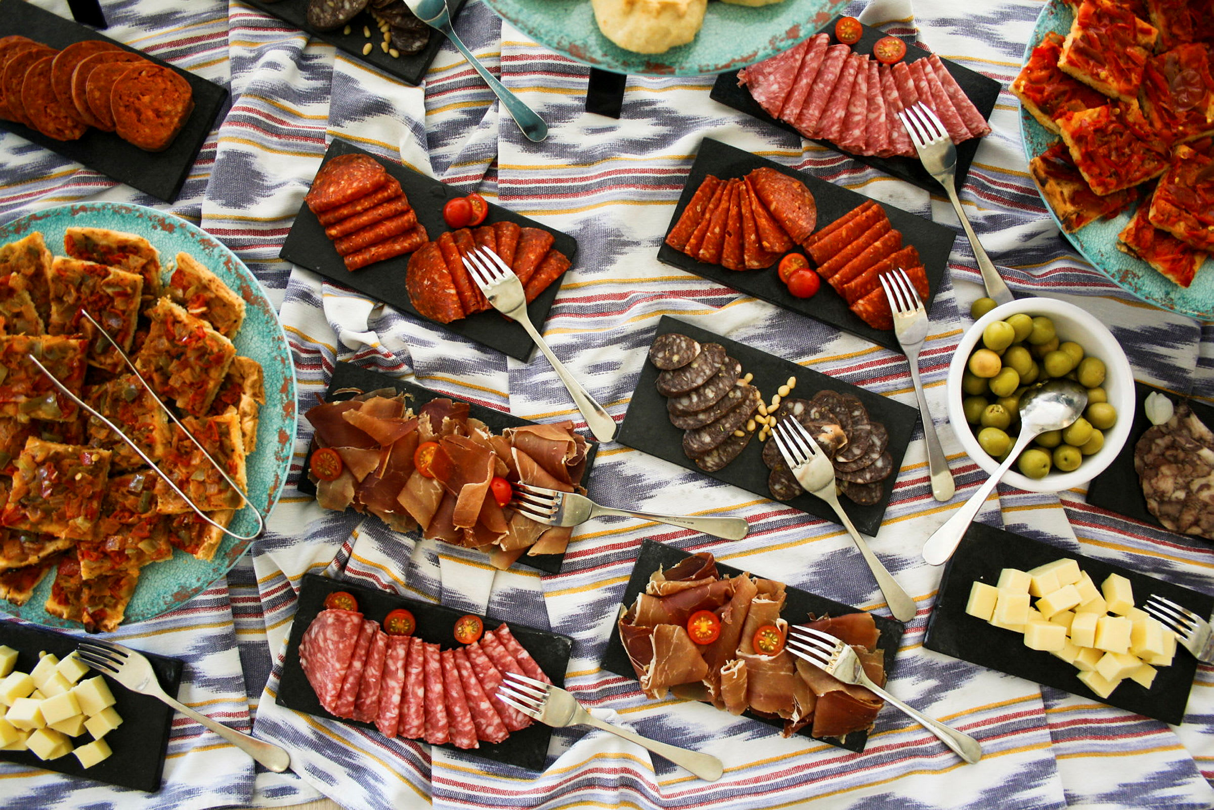 En matdisplay med olika tapas inklusive charkuterier, ost och oliver. (AI-genererad text)