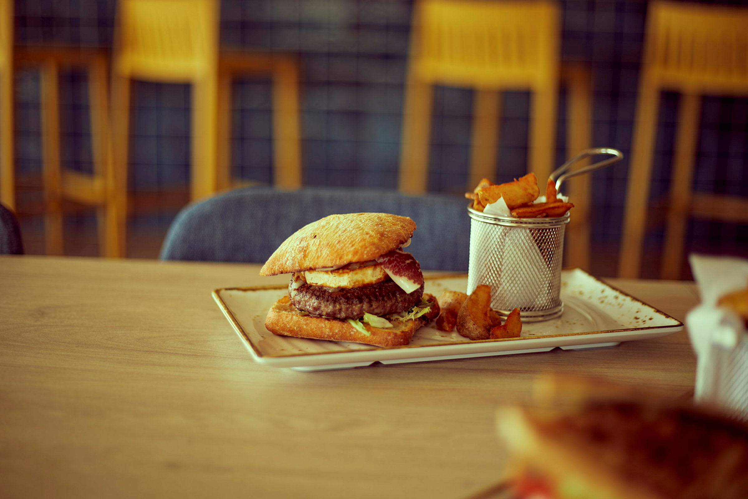 En tallrik med hamburgare och tillhörande pommes frites. (AI-genererad text)