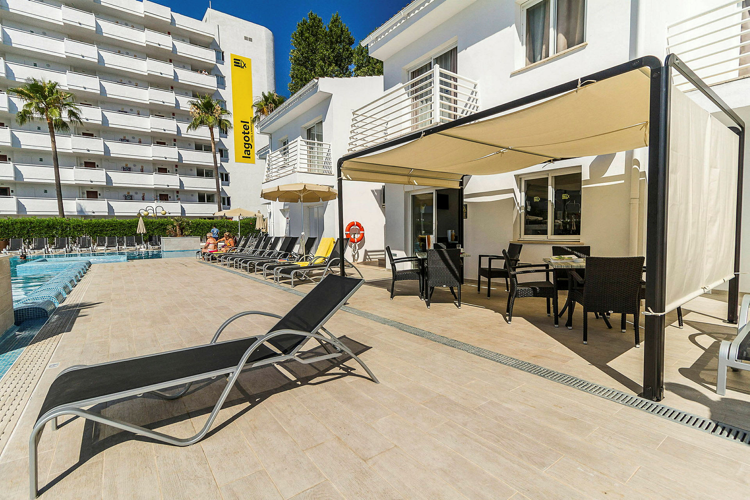 Bild av ett poolområde vid ett hotell med solstolar, parasoll och utomhusmöbler. (AI-genererad text)