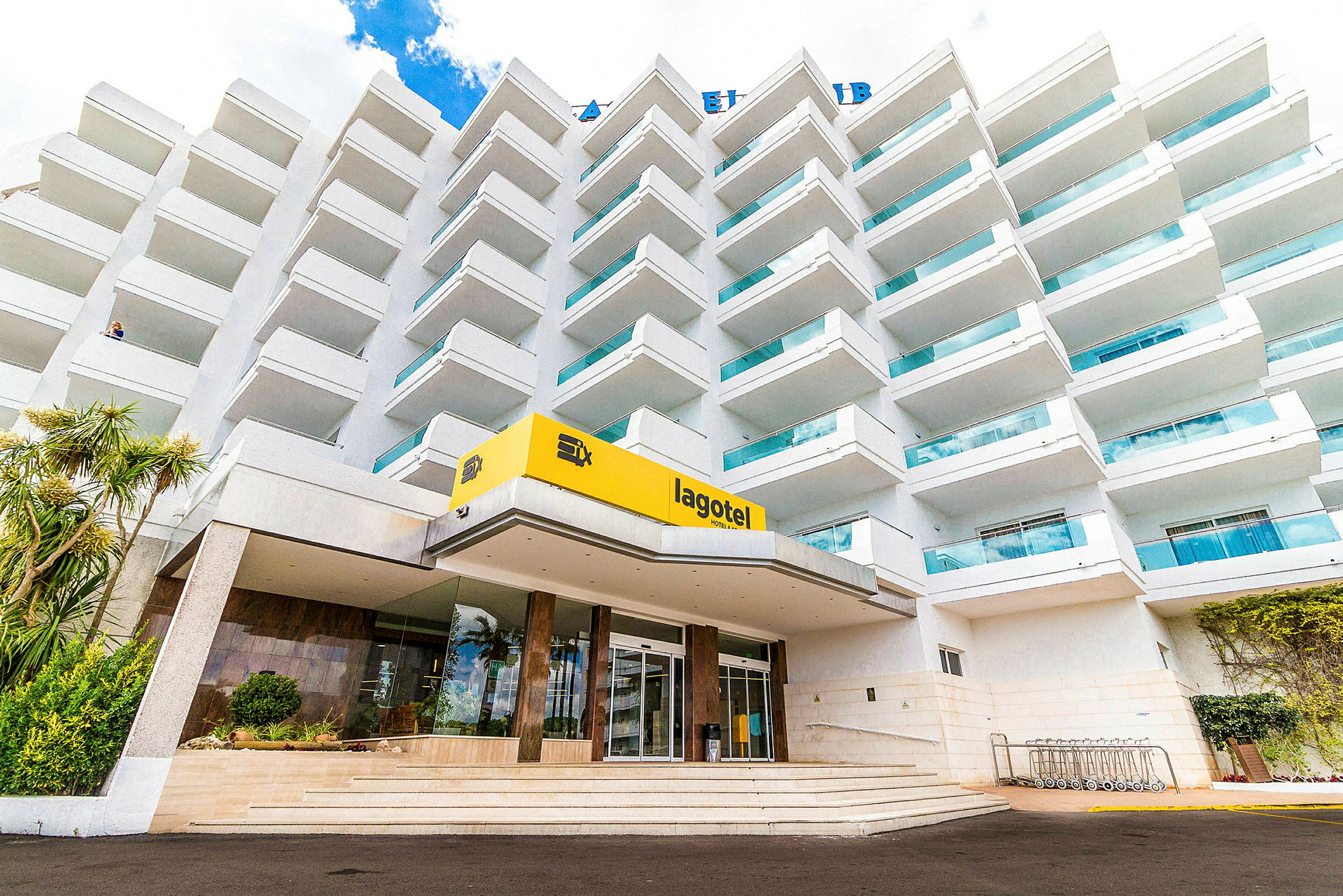 Ett flerbostadshotell med balkonger och en ingång markerad med en gul skylt där det står 'lagotel'. (AI-genererad text)