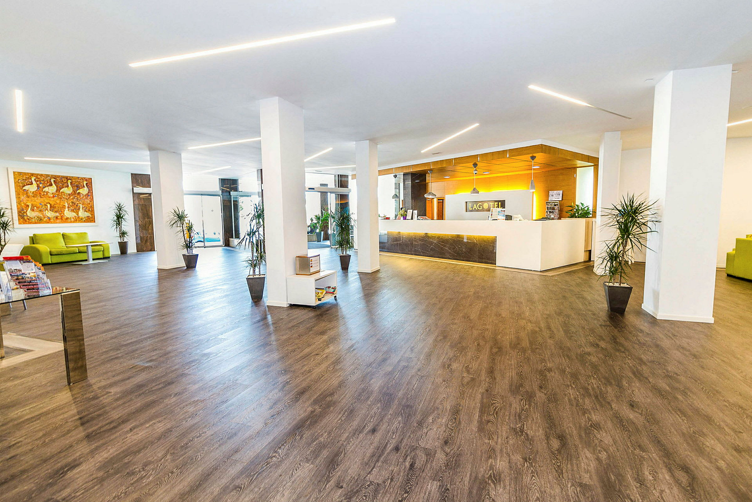 Bild av en hotelllobby med modern inredning, trägolv och en receptionsdisk. (AI-genererad text)