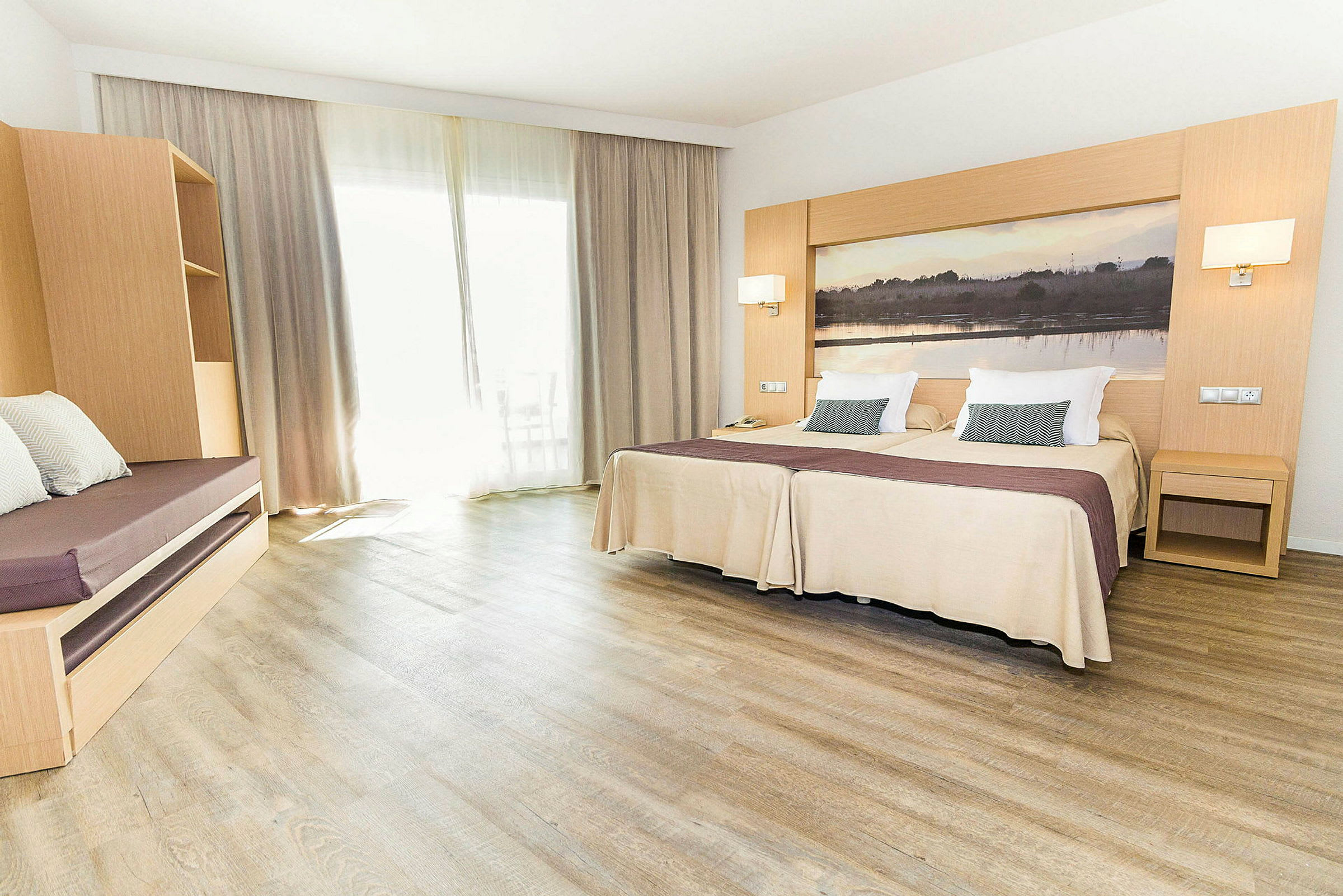 Hotellrum med två enkelsängar, en sittmöbel och stora gardiner. (AI-genererad text)
