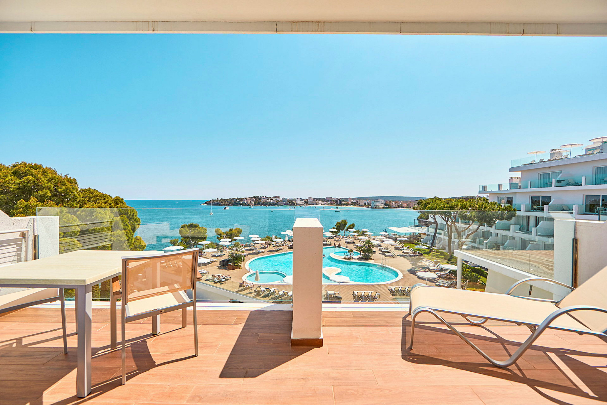 Hotellrumsvy mot poolområde och hav. (AI-genererad text)