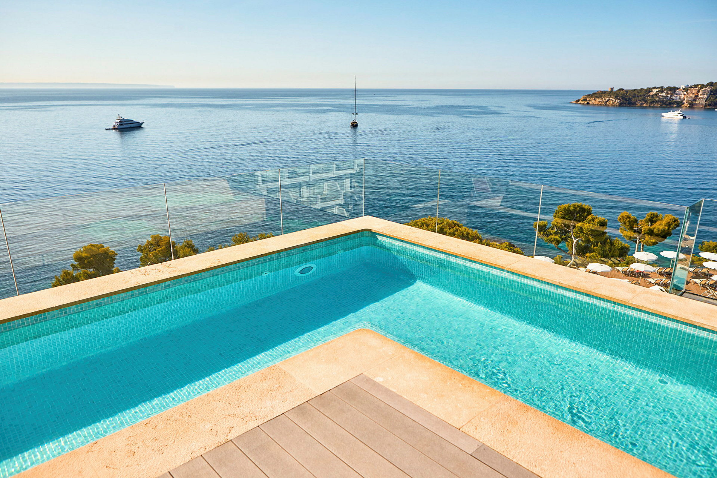 Bild på en pool med utsikt över havet och båtar. (AI-genererad text)
