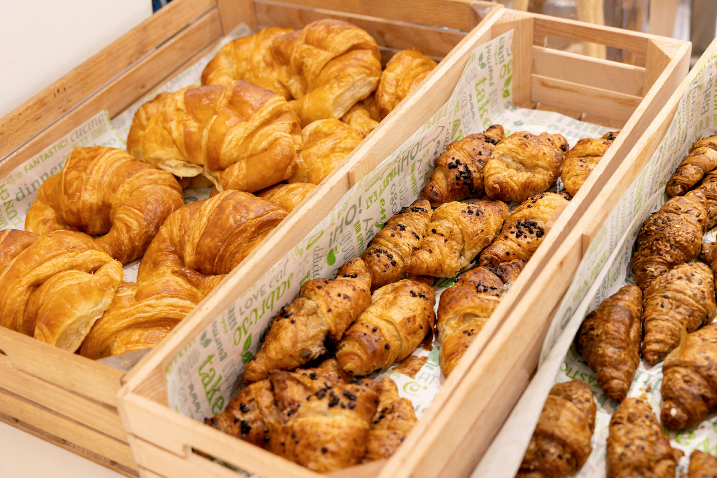 Bild av träkorgar fyllda med olika typer av croissanter. (AI-genererad text)