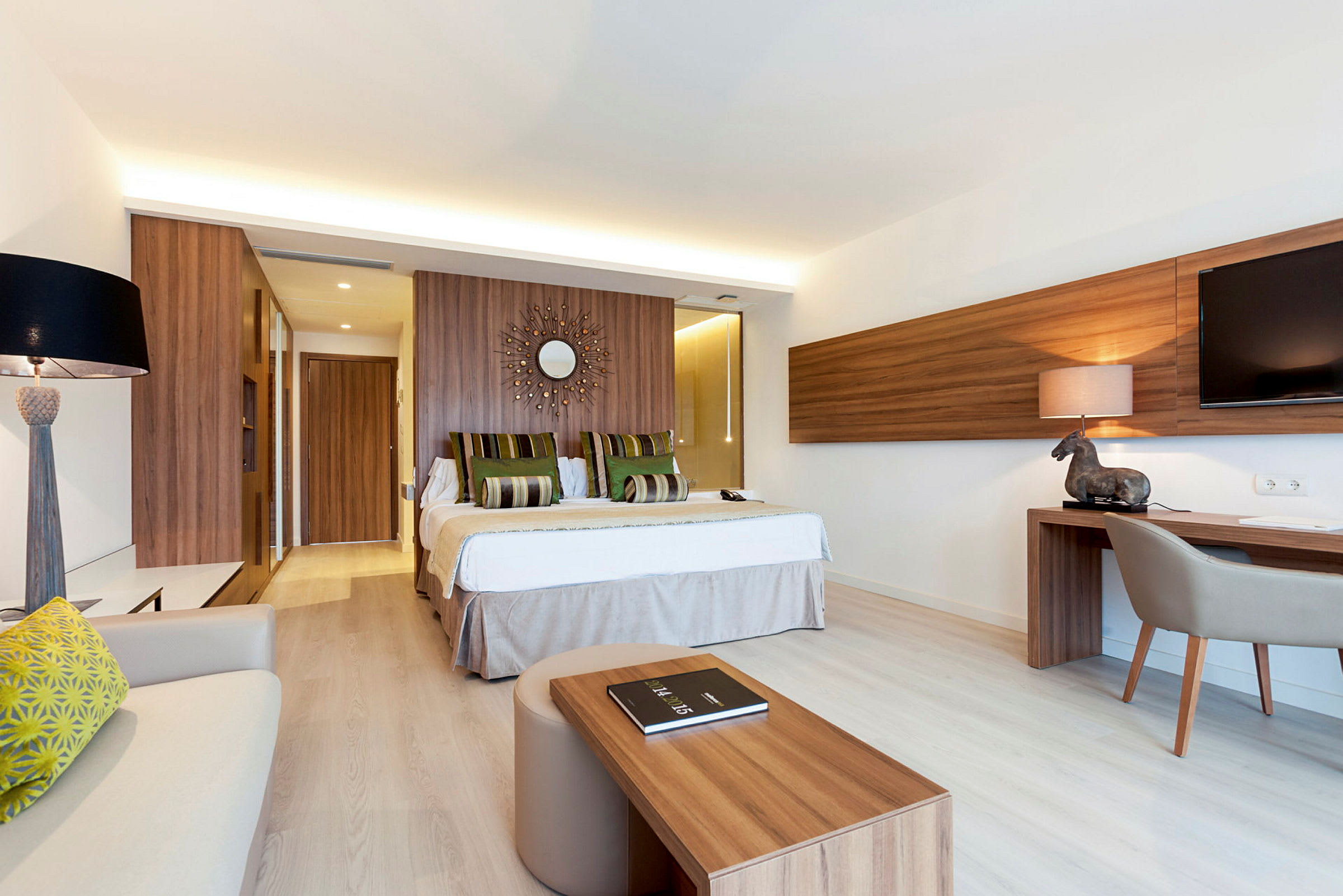 Modernt hotellrum med dubbelsäng, skrivbord och ljus inredning. (AI-genererad text)