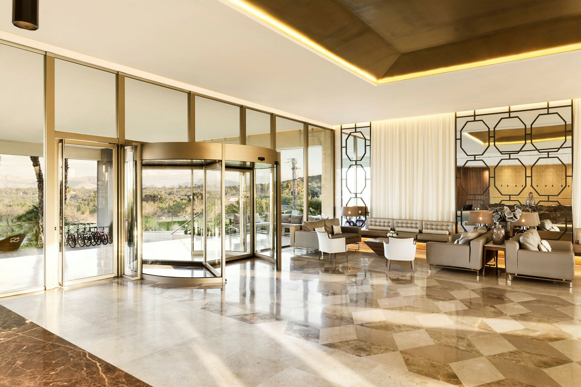 Ett modernt hotellobby med en glasvägg och snurrdörr. (AI-genererad text)