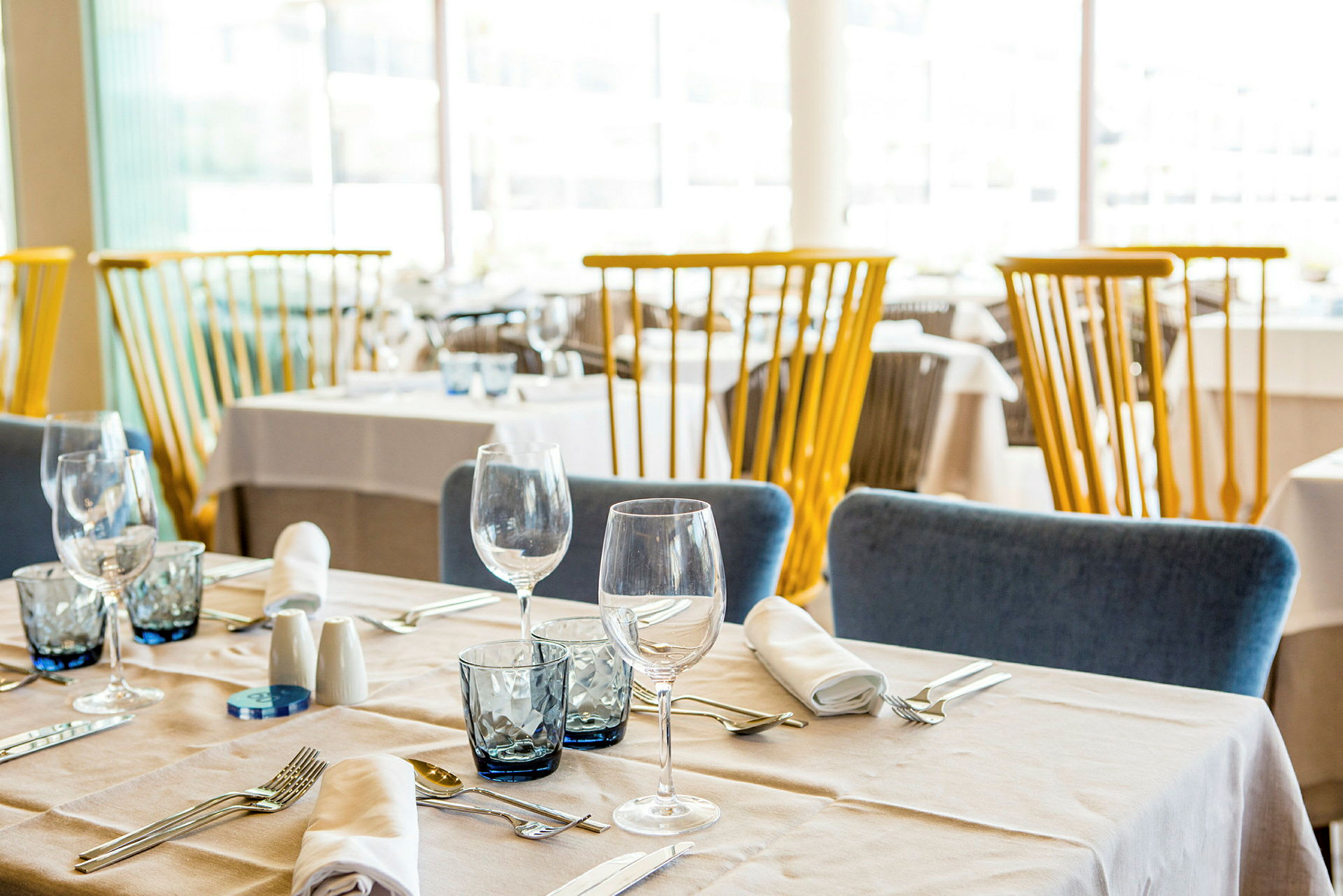 Inredd restaurang med dukade bord och stolar. (AI-genererad text)