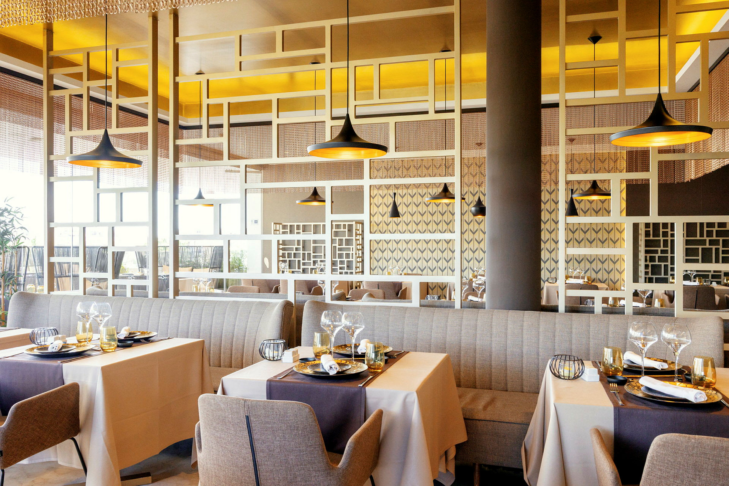 Bild av en elegant restaurang med bord dukade för måltider och moderna dekorativa detaljer. (AI-genererad text)