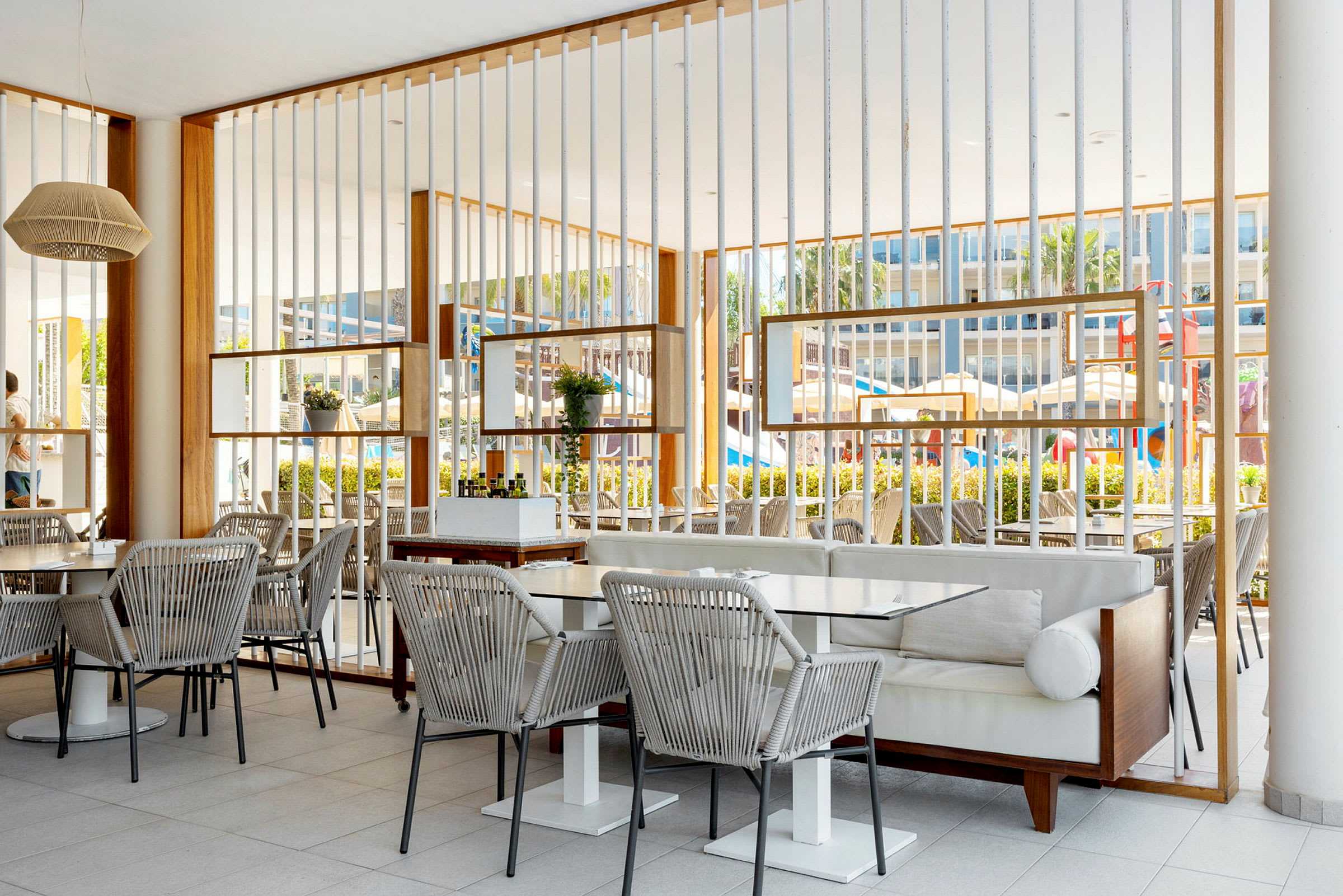 En utomhusrestaurang med bord och stolar och en modern inredning. (AI-genererad text)