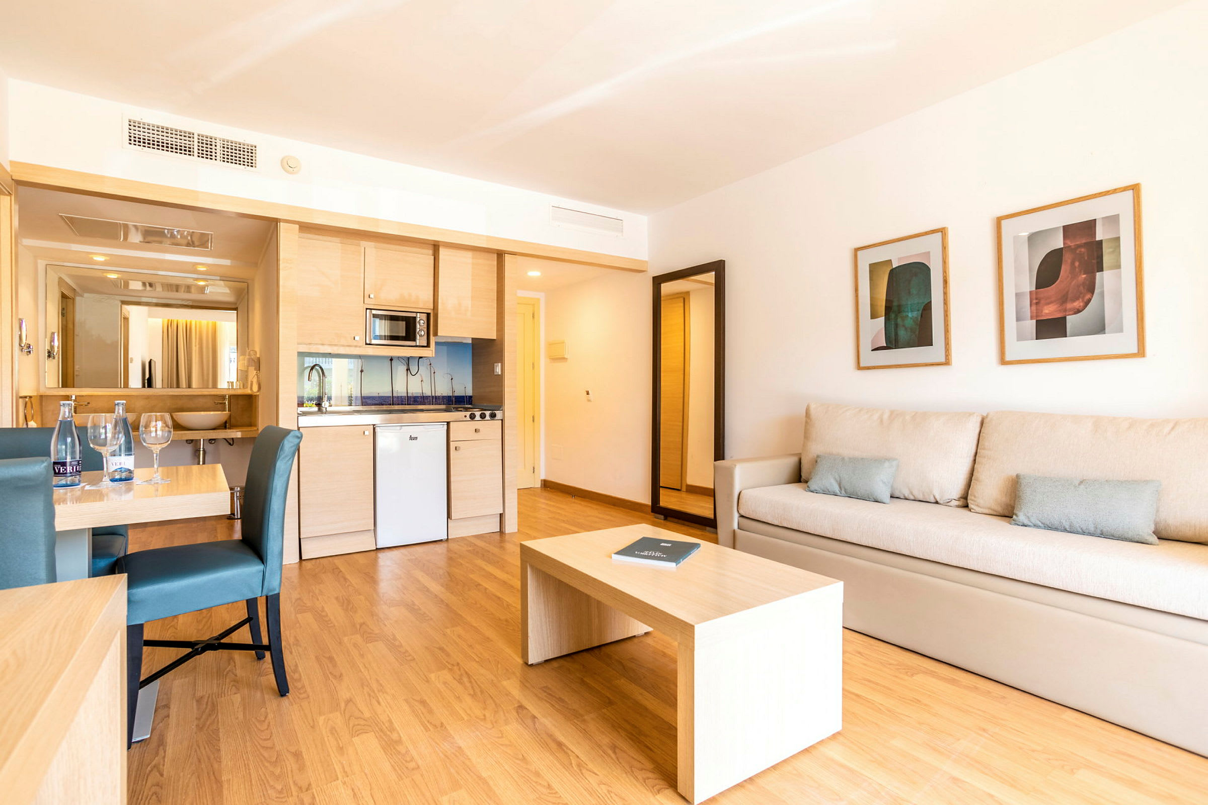 Ett hotellrum med kök, matbord och soffa. (AI-genererad text)
