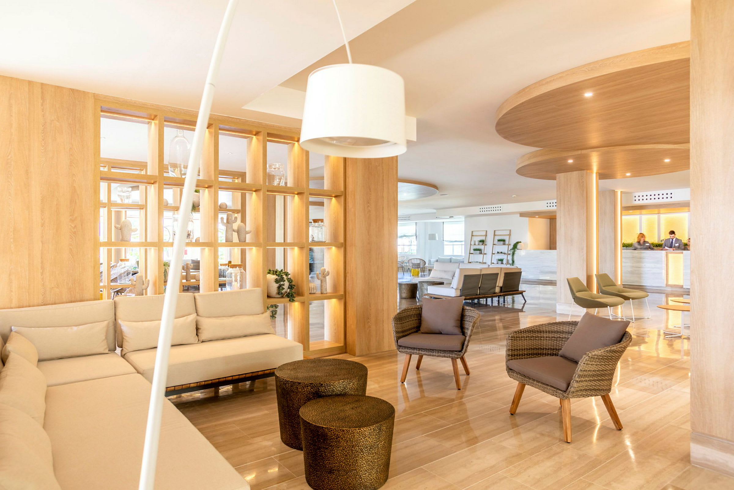 Ett ljust och modernt hotellobbyområde med soffor, fåtöljer och dekorativa hyllor. (AI-genererad text)