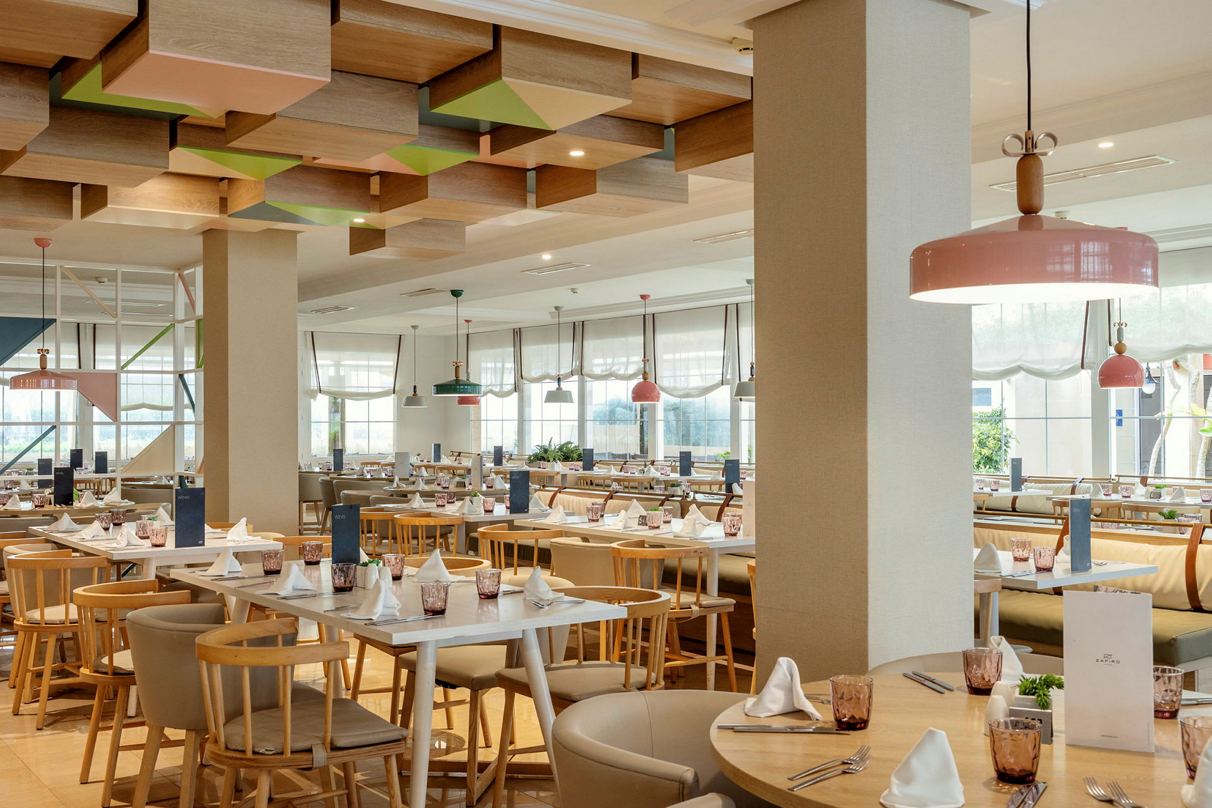 Restaurang med ljusa möbler och dekorerat tak. (AI-genererad text)