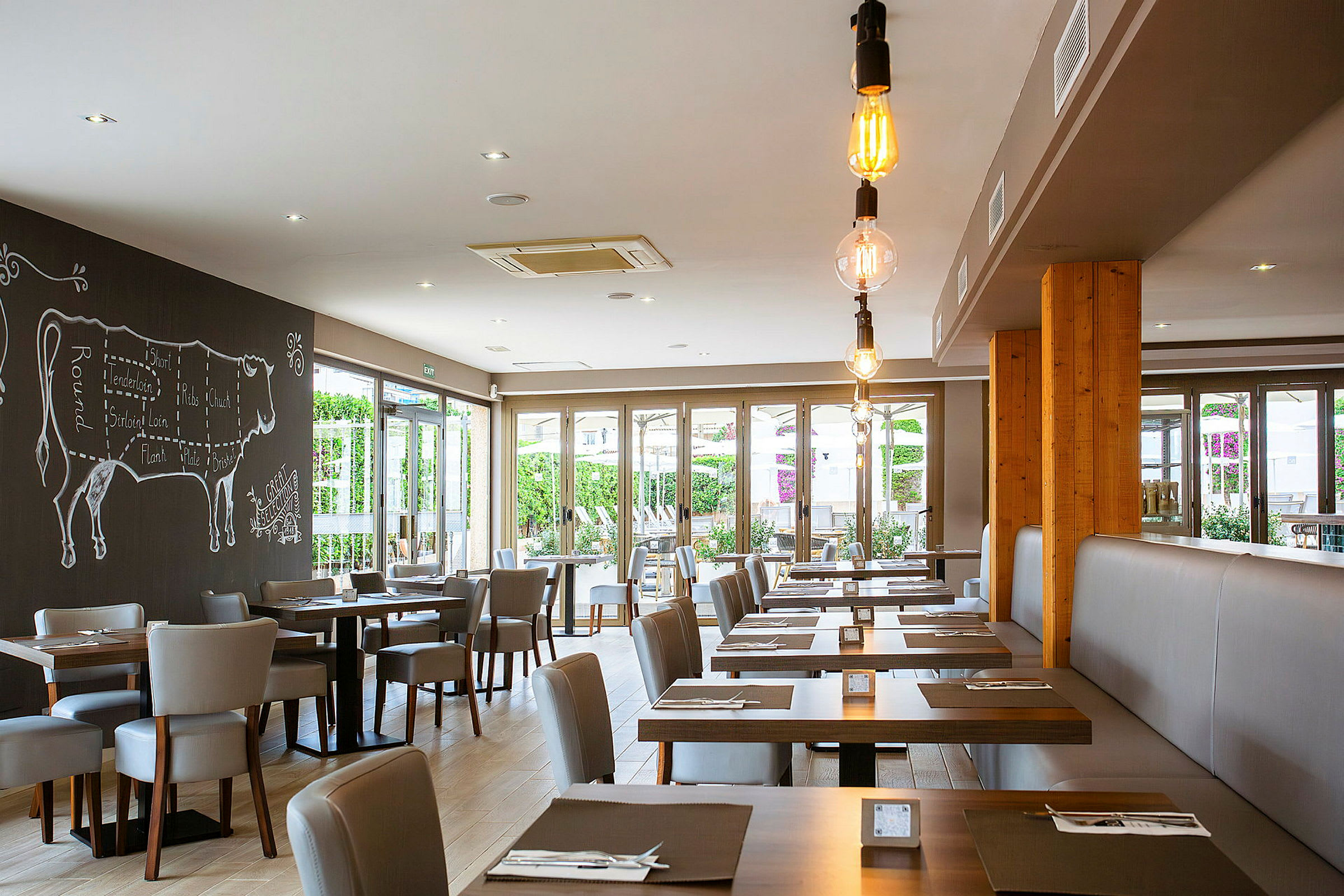 En modern restaurang med bord och stolar, dekorerad med en väggmålning av en ko. (AI-genererad text)
