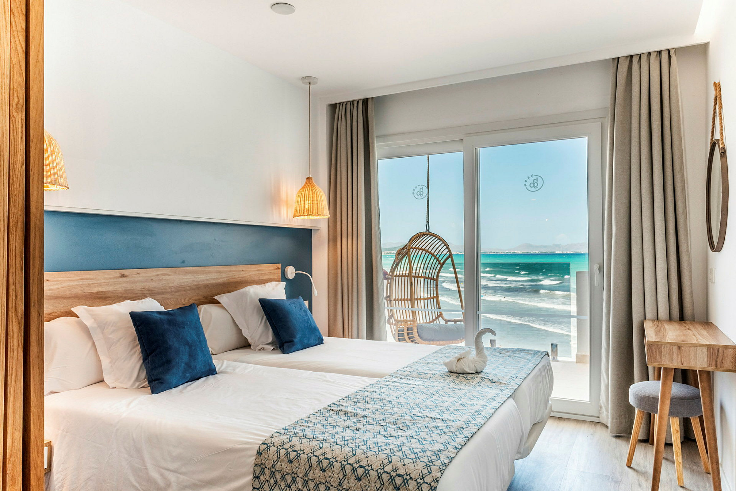 Ett hotellrum med två sängar och en utsikt över havet. (AI-genererad text)