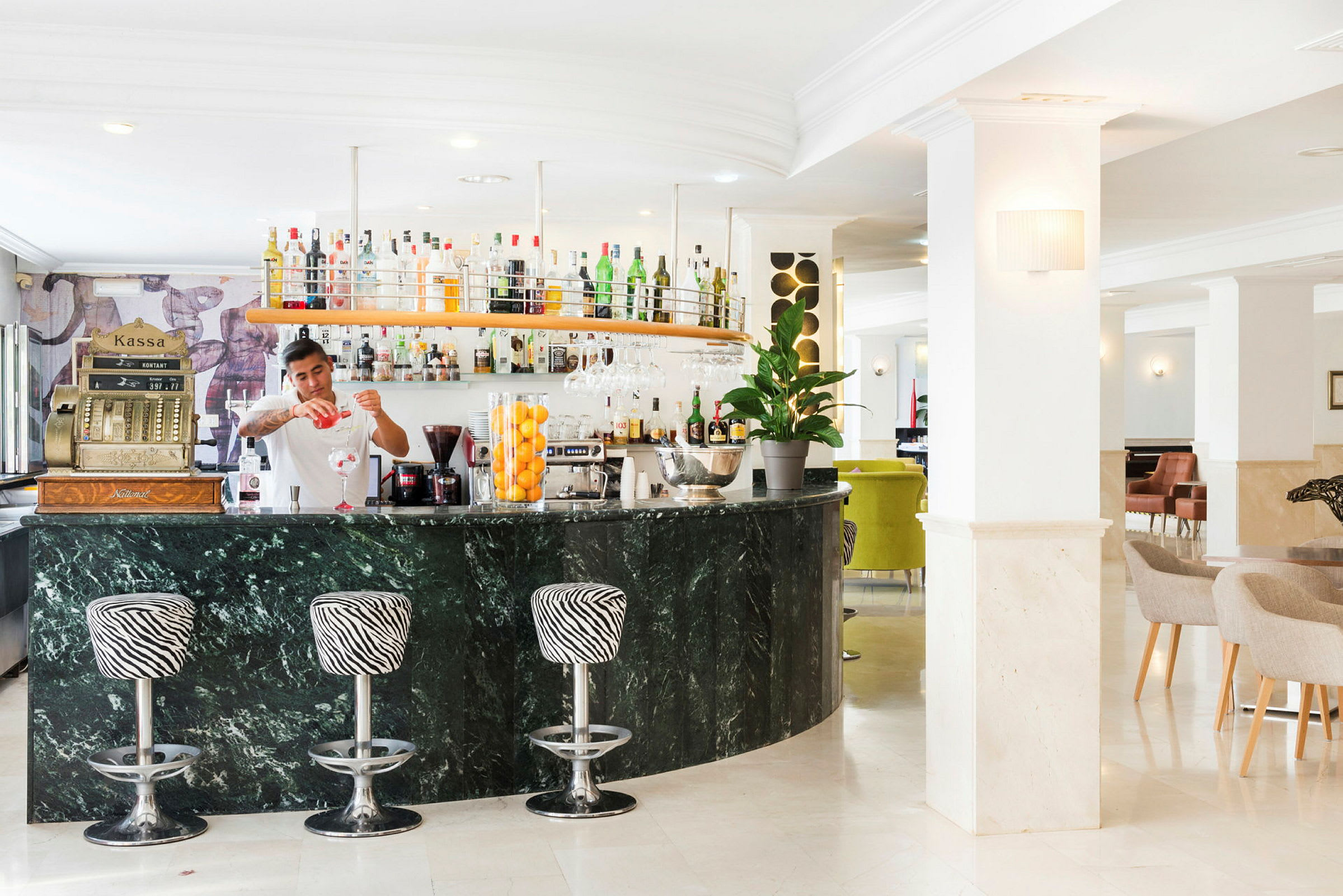En välbelyst hotellbar med marmordisk och zebra-mönstrade barstolar. (AI-genererad text)