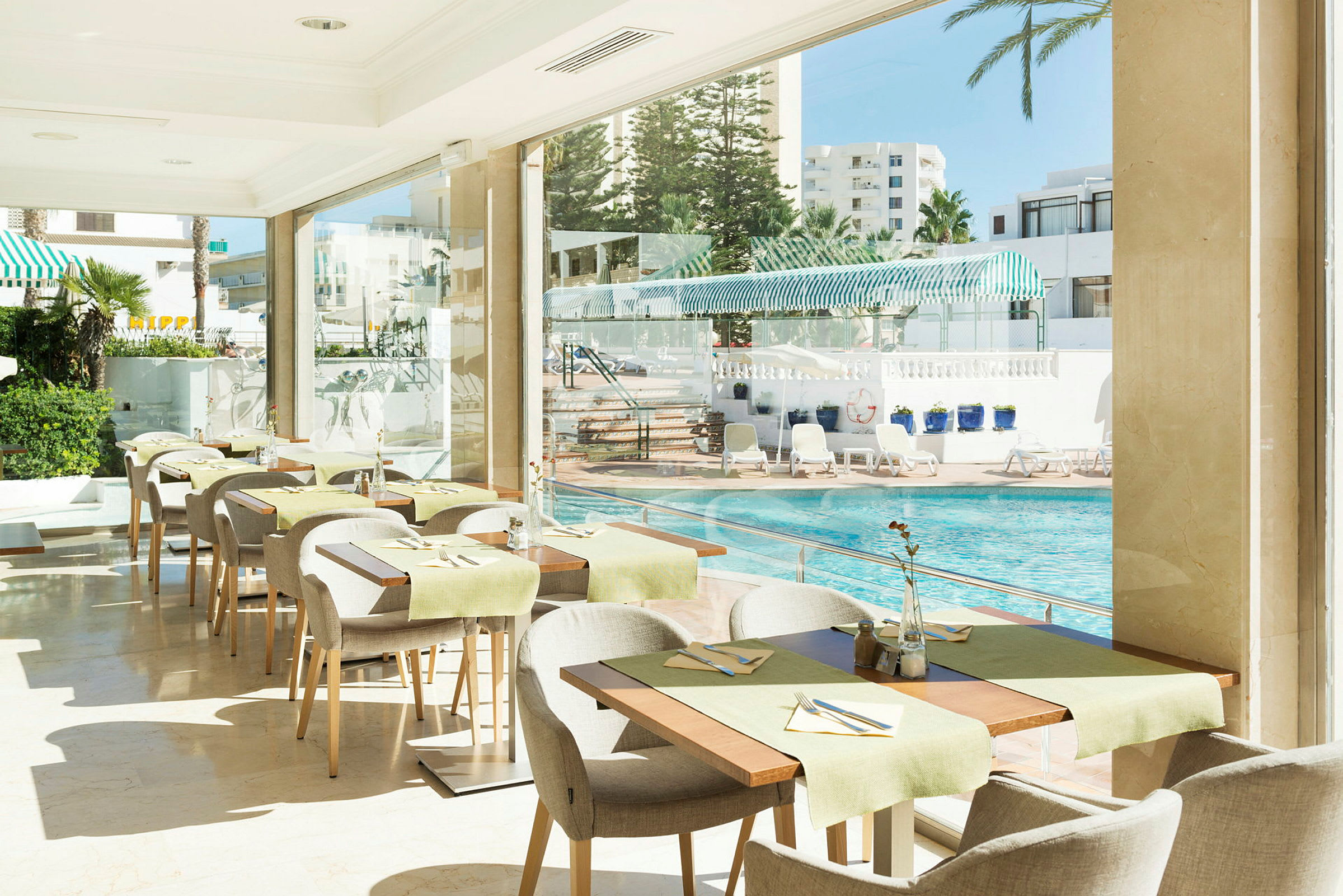 En restaurang med utsikt över en pool och solstolar. (AI-genererad text)