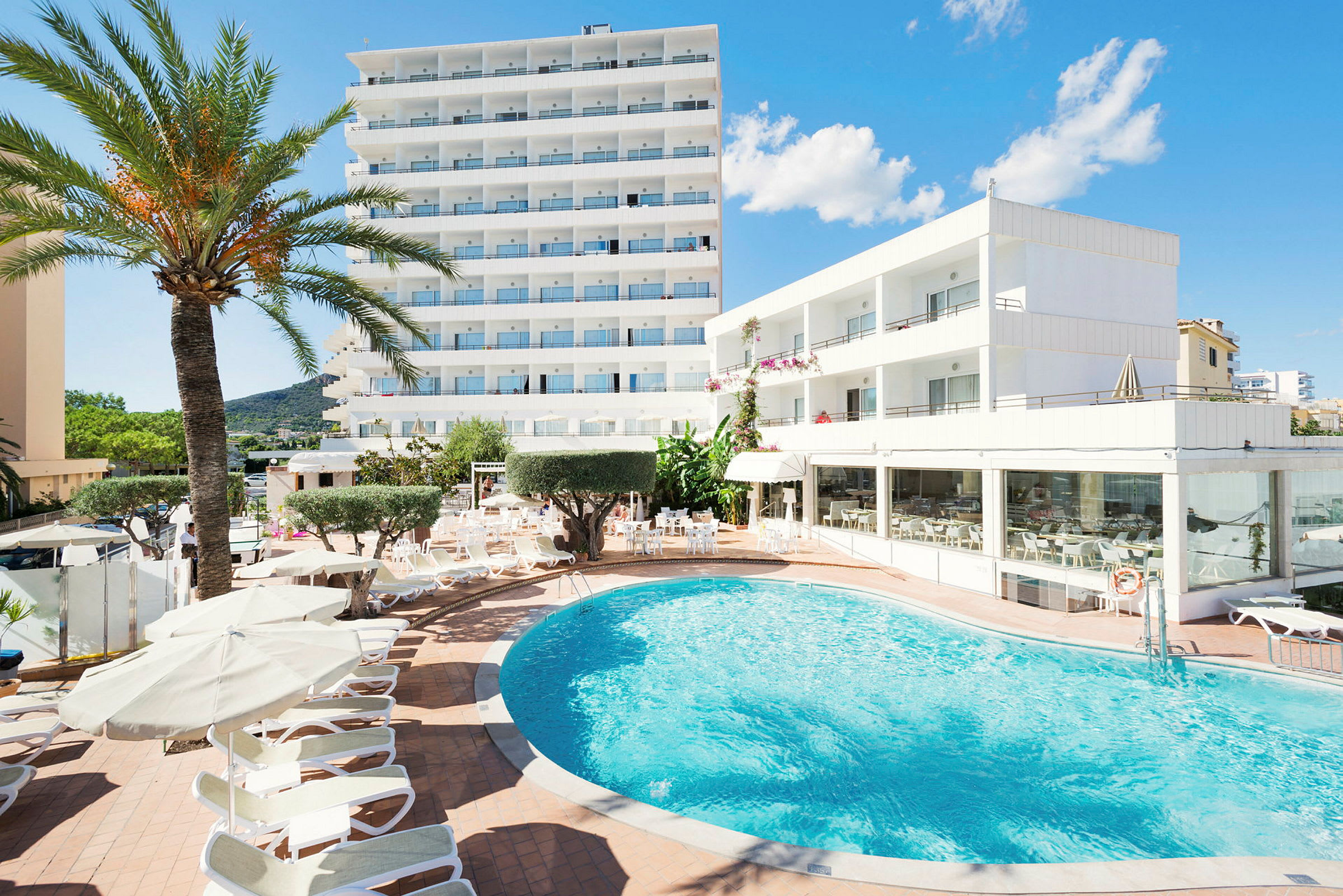Hotell med pool och solstolar. (AI-genererad text)