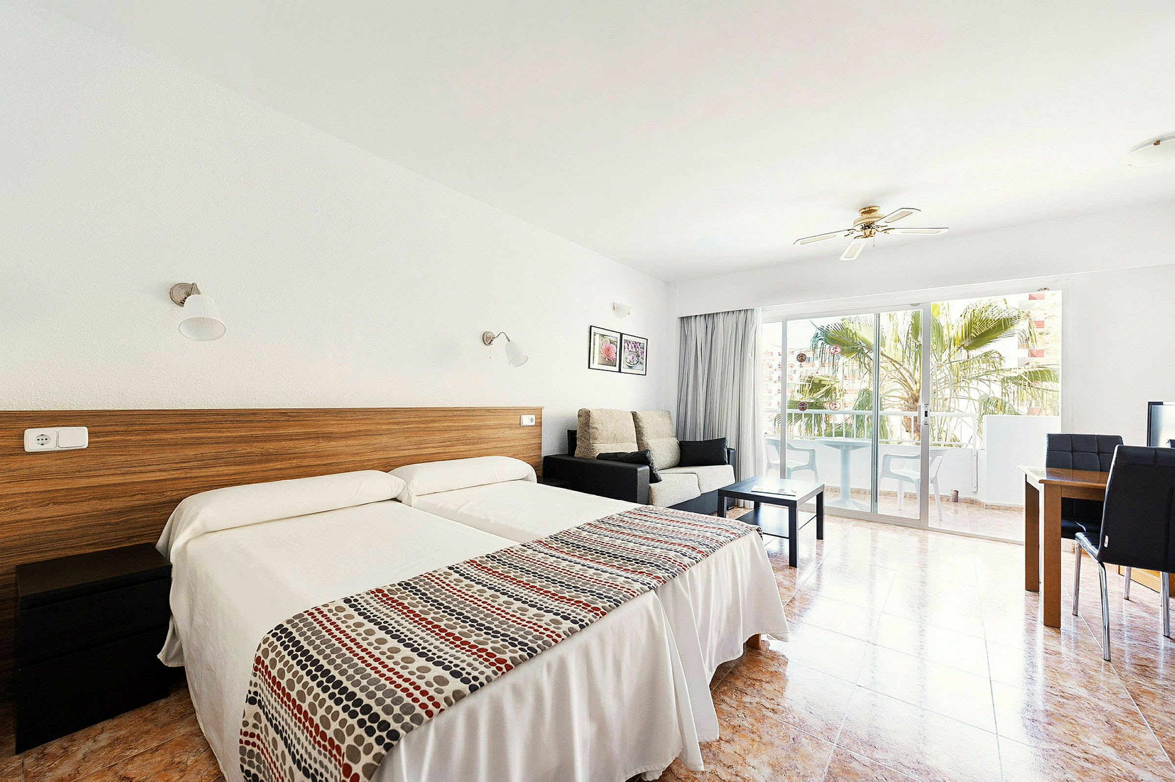 Hotellets rum med två enkelsängar, sittgrupp och balkong. (AI-genererad text)
