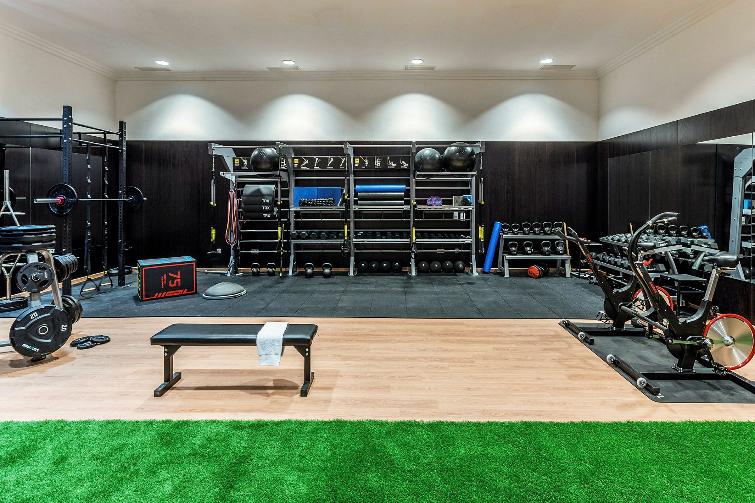Ett gym med träningsutrustning som maskiner, hantlar och bänkar. (AI-genererad text)