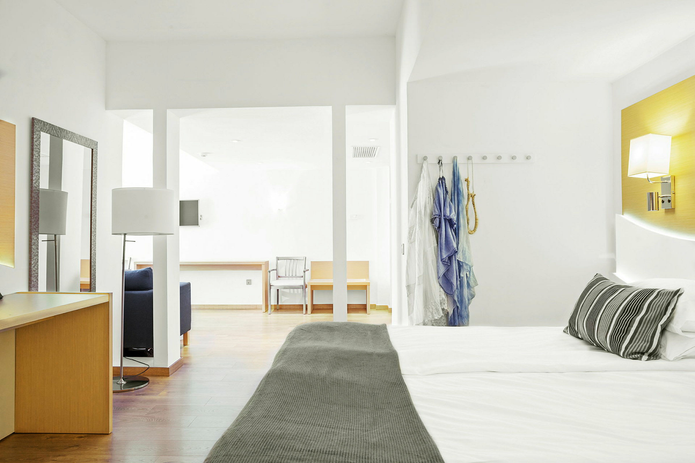 Hotellrum med en dubbelsäng, skrivbord och sittmöbler. (AI-genererad text)