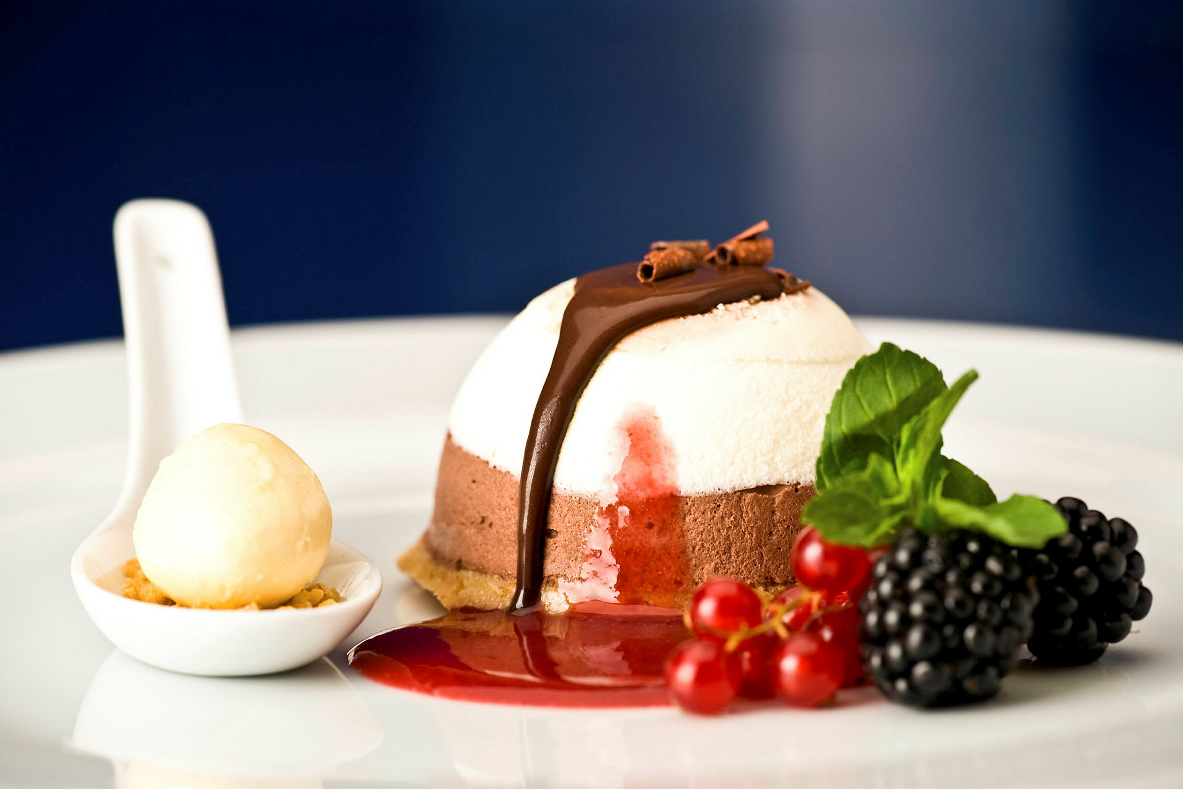 Dessert med choklad och vanilj, dekorerad med bär och mintblad. (AI-genererad text)