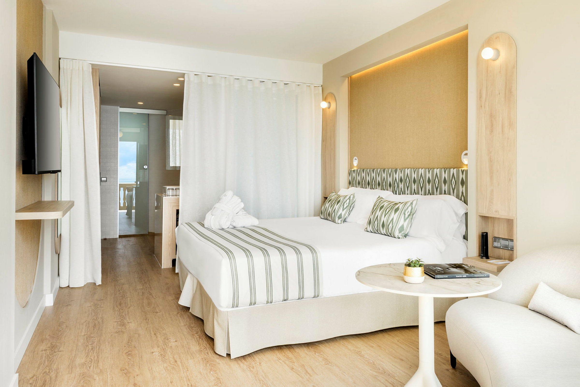 Bild av ett modernt hotellrum med dubbelsäng, sittområde och öppning mot badrum. (AI-genererad text)