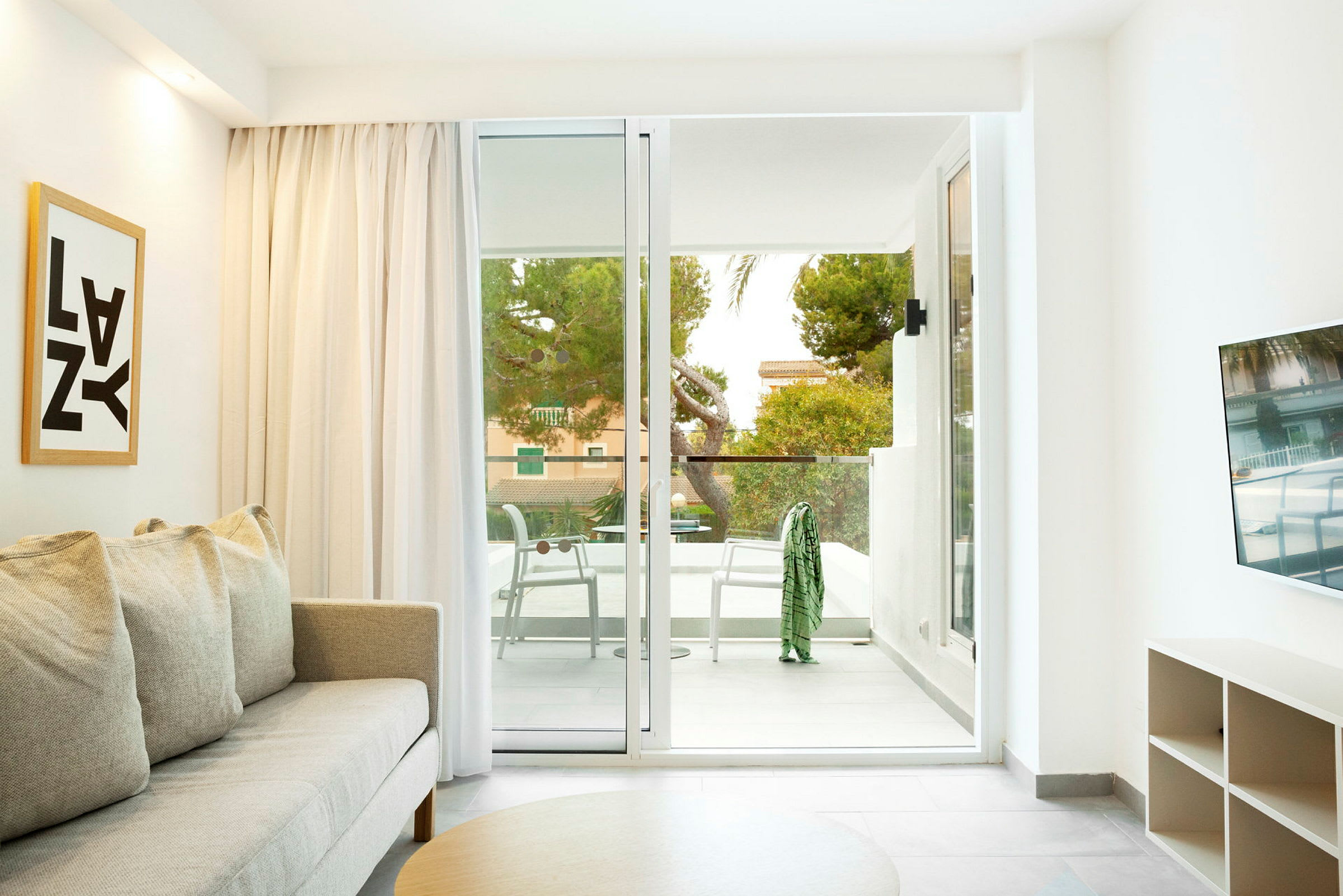 Ett rymligt hotellrum med en soffa, ett soffbord och en balkong med sittplats. (AI-genererad text)