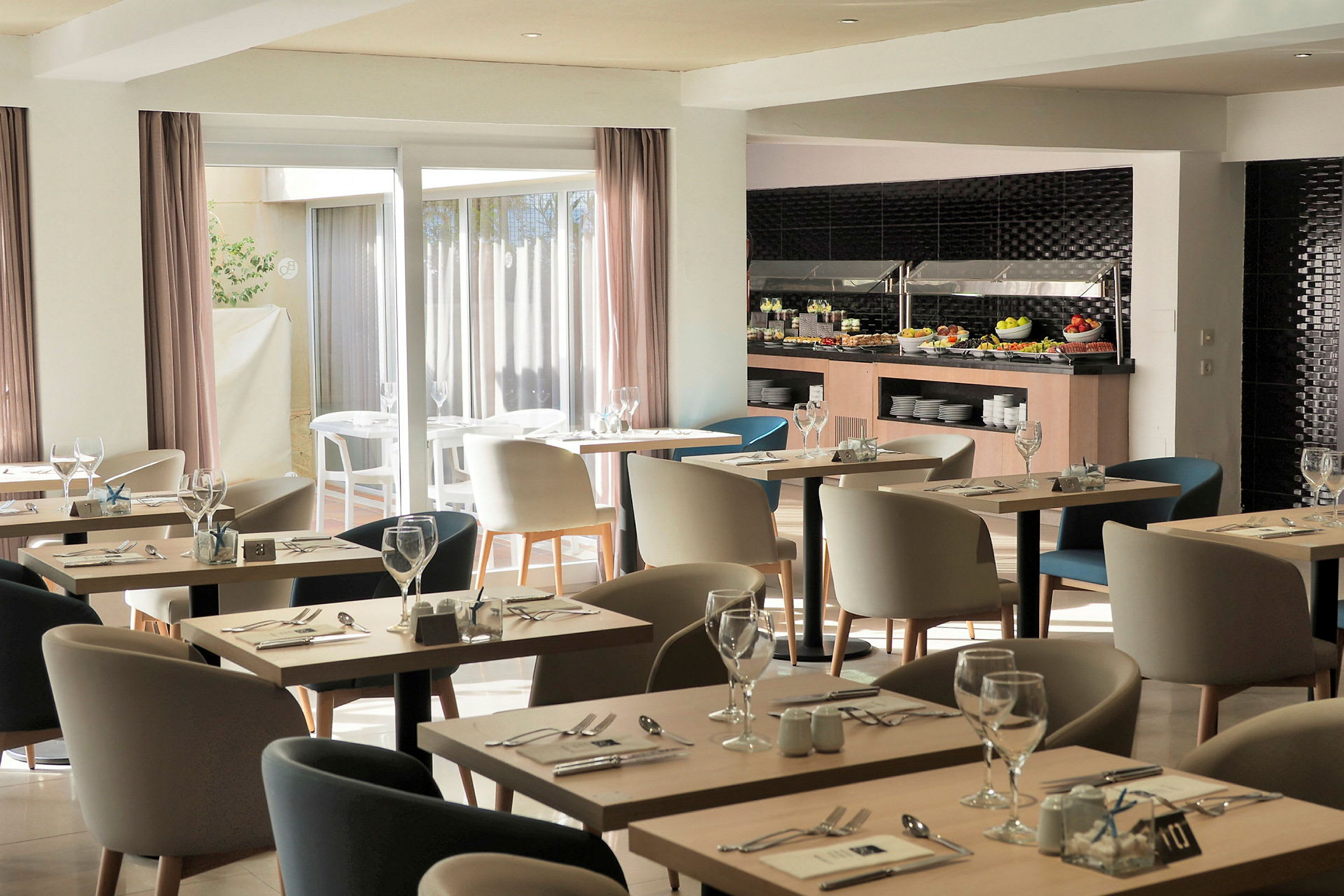Bild av en modern restaurang med bord och stolar, samt en bufféplats med mat. (AI-genererad text)