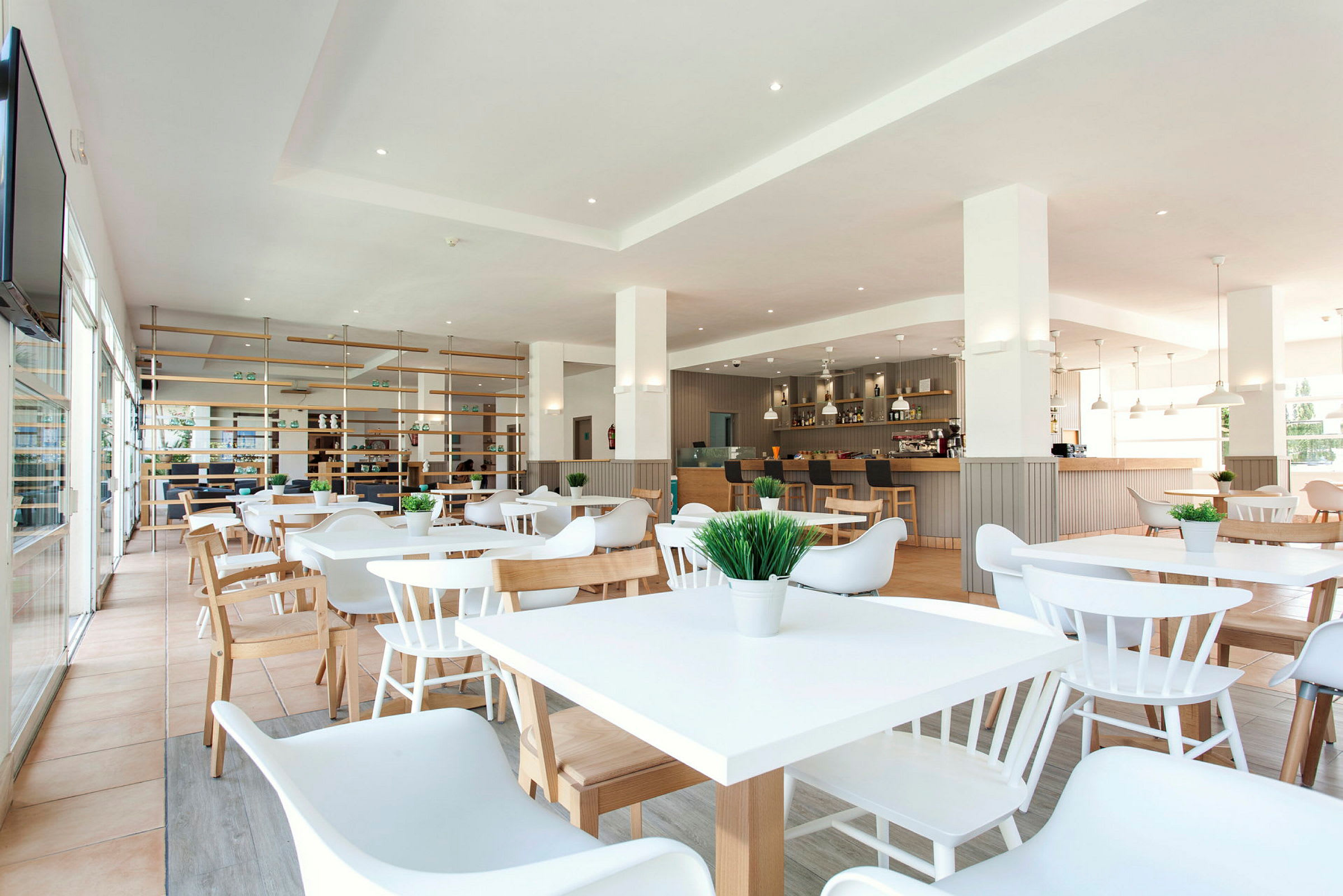 En modern restaurang med vita möbler och trädetaljer. (AI-genererad text)