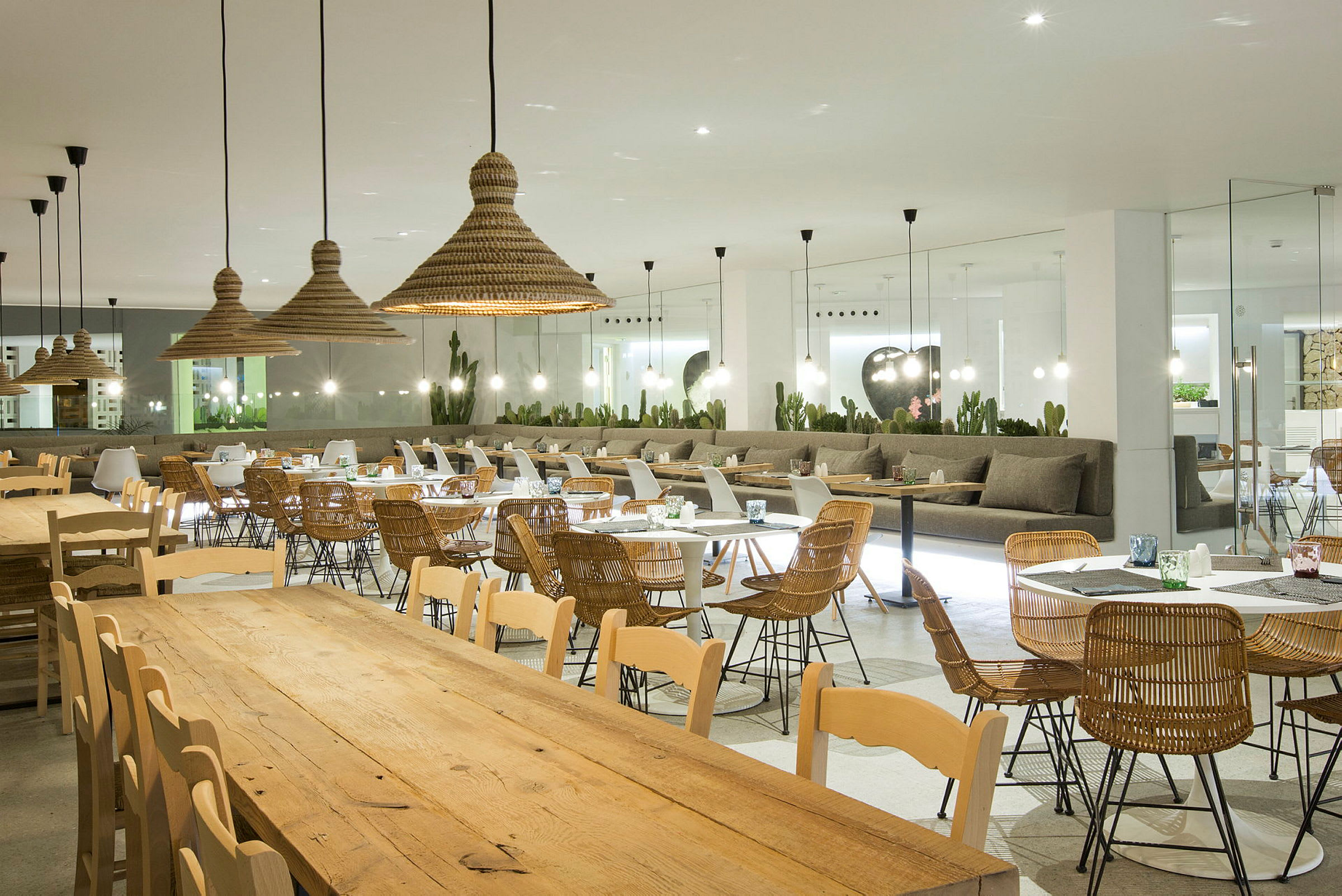 Öppen restaurang med bord och stolar i trä samt rotting. (AI-genererad text)
