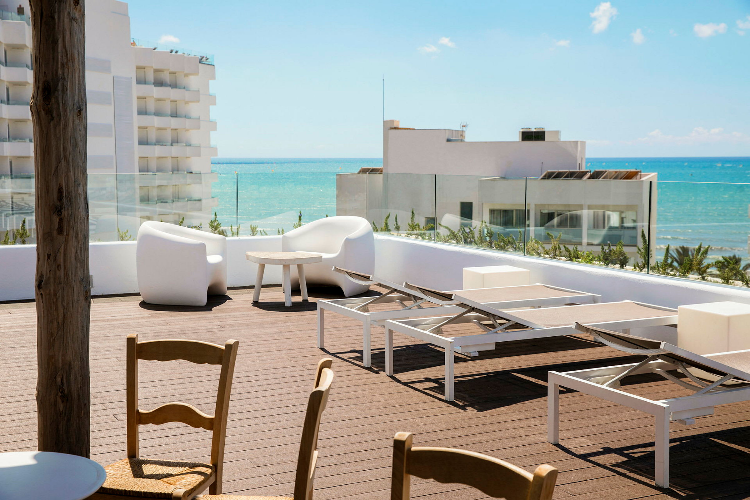 En solterrass med solsängar och sittgrupp, med utsikt mot havet. (AI-genererad text)