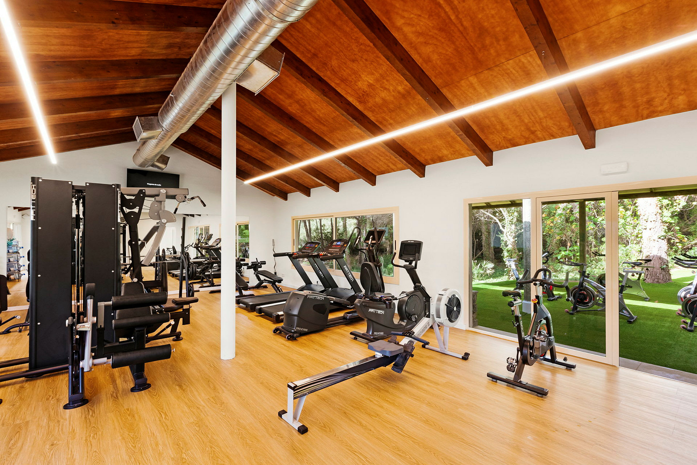 Gym med träningsutrustning och stora fönster. (AI-genererad text)