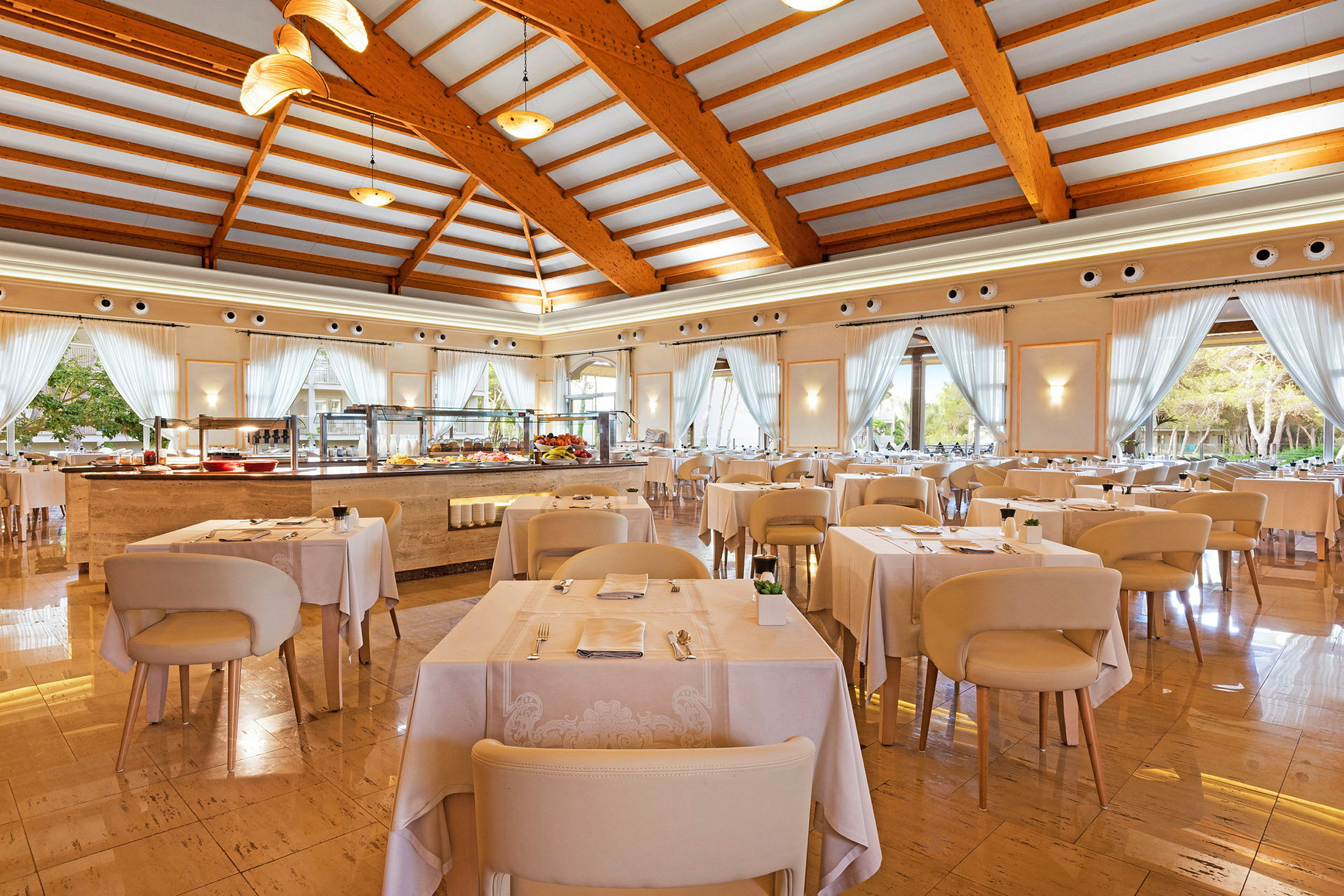En ljus restaurang med dukade bord och stora fönster. (AI-genererad text)