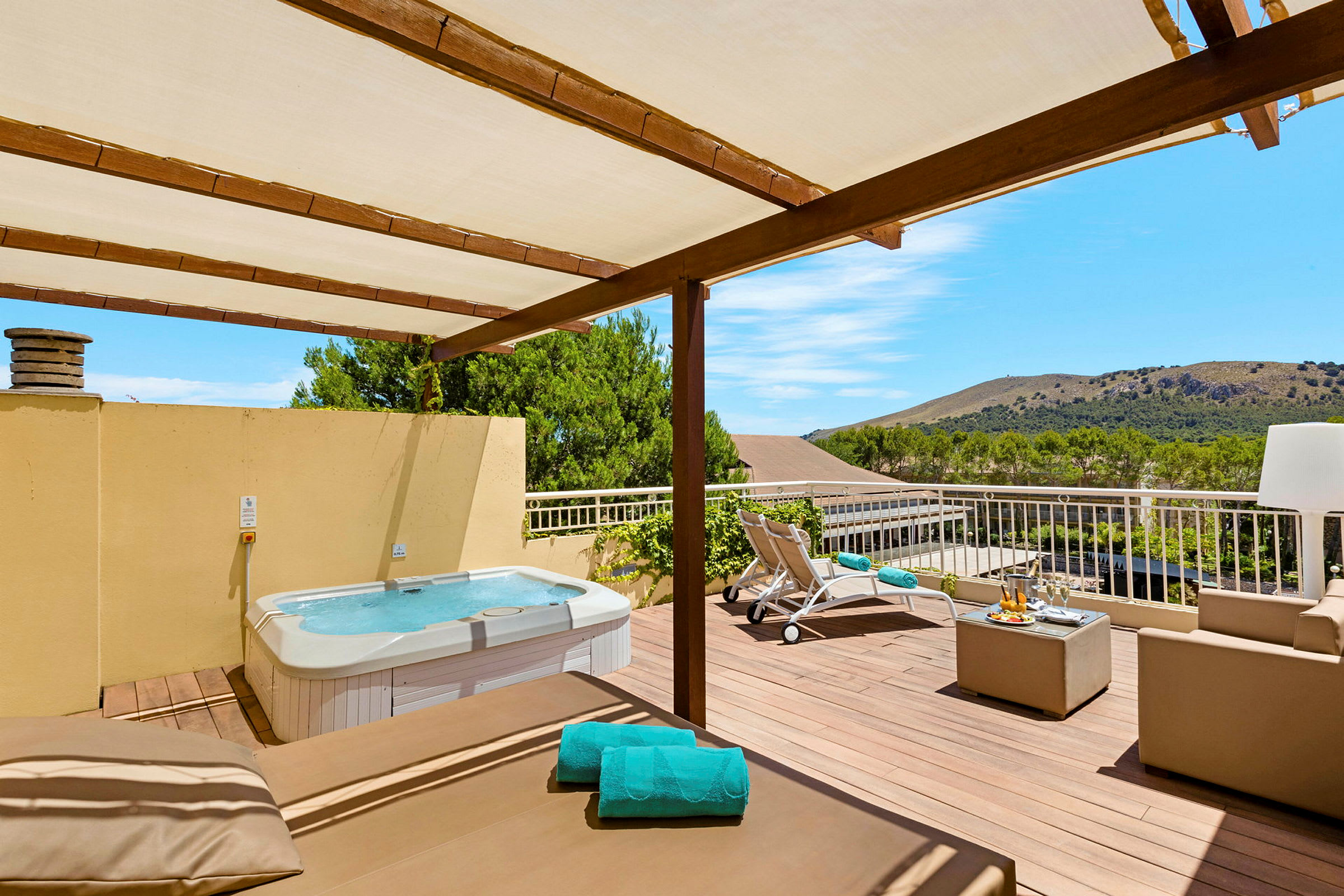 Luftig terrass med jacuzzi, solsängar och sittgrupp under ett träpergola. (AI-genererad text)