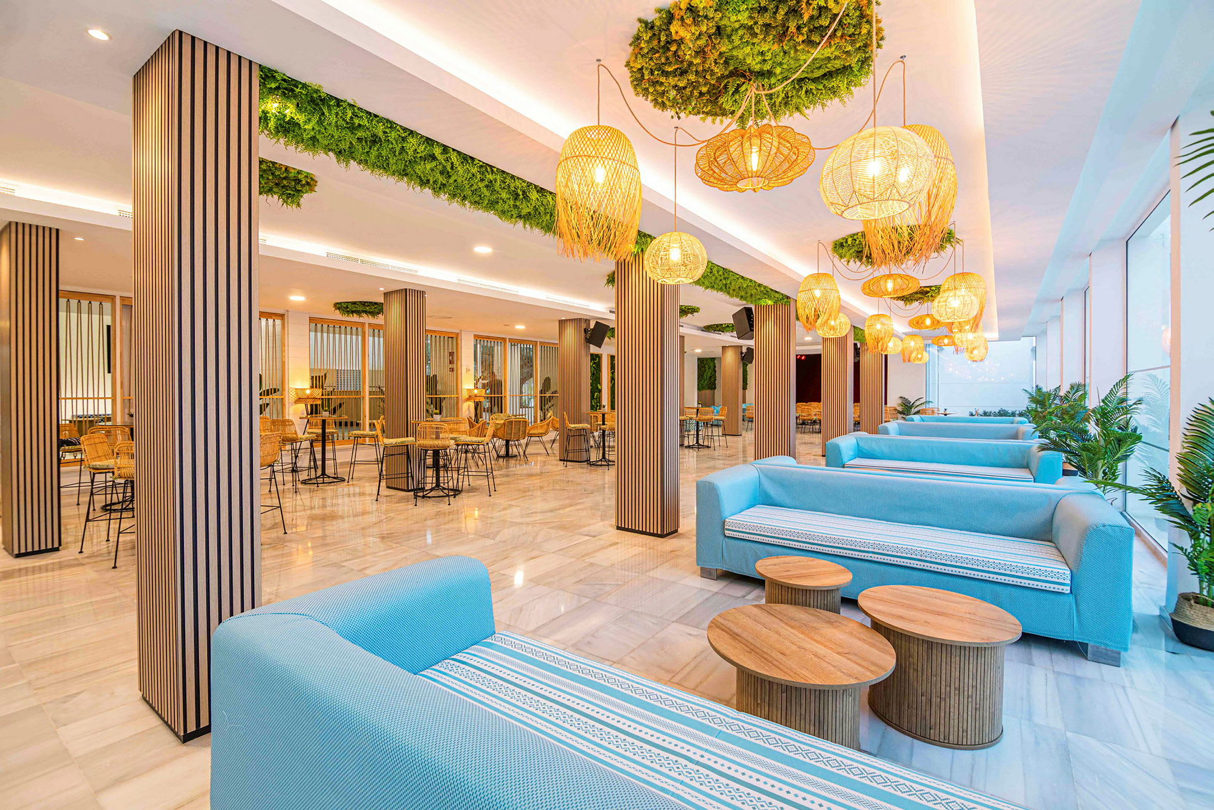 En modern lounge med blå soffor, träbord och designlampor i en ljus miljö. (AI-genererad text)