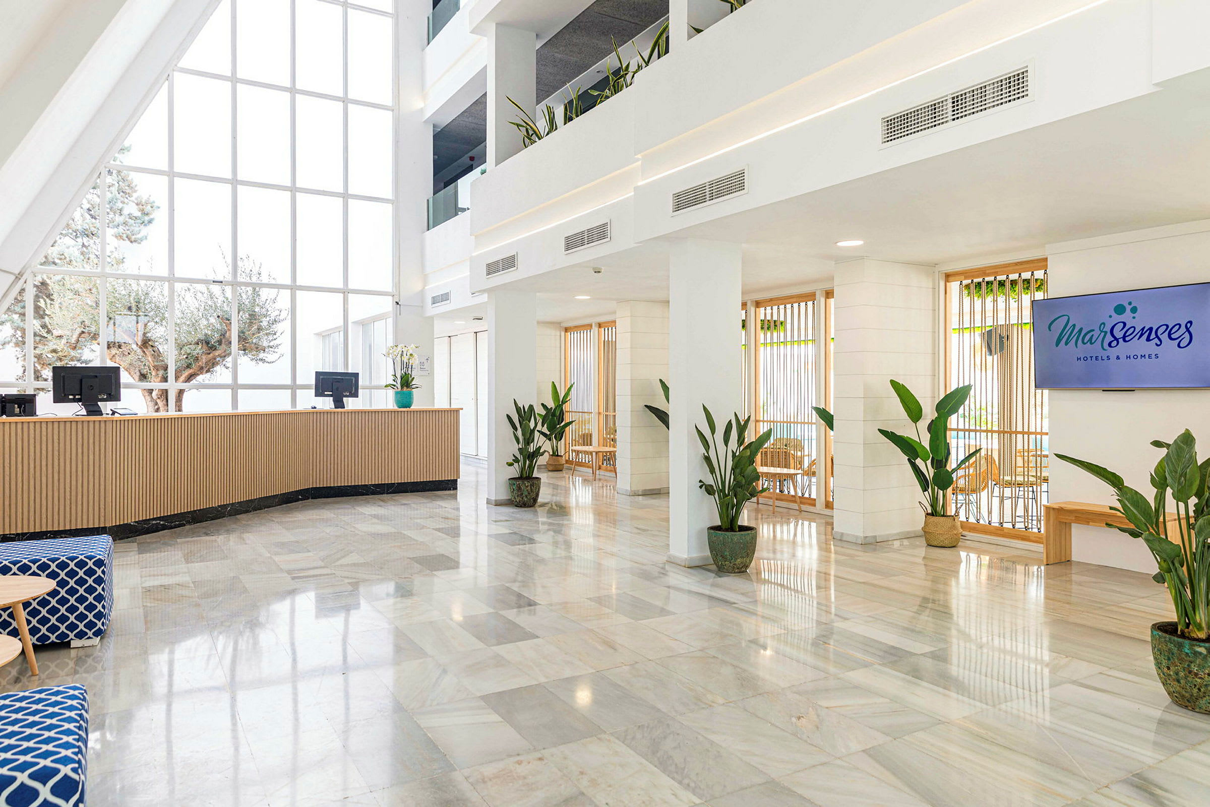 Hotellreception med stora fönster och växter. (AI-genererad text)