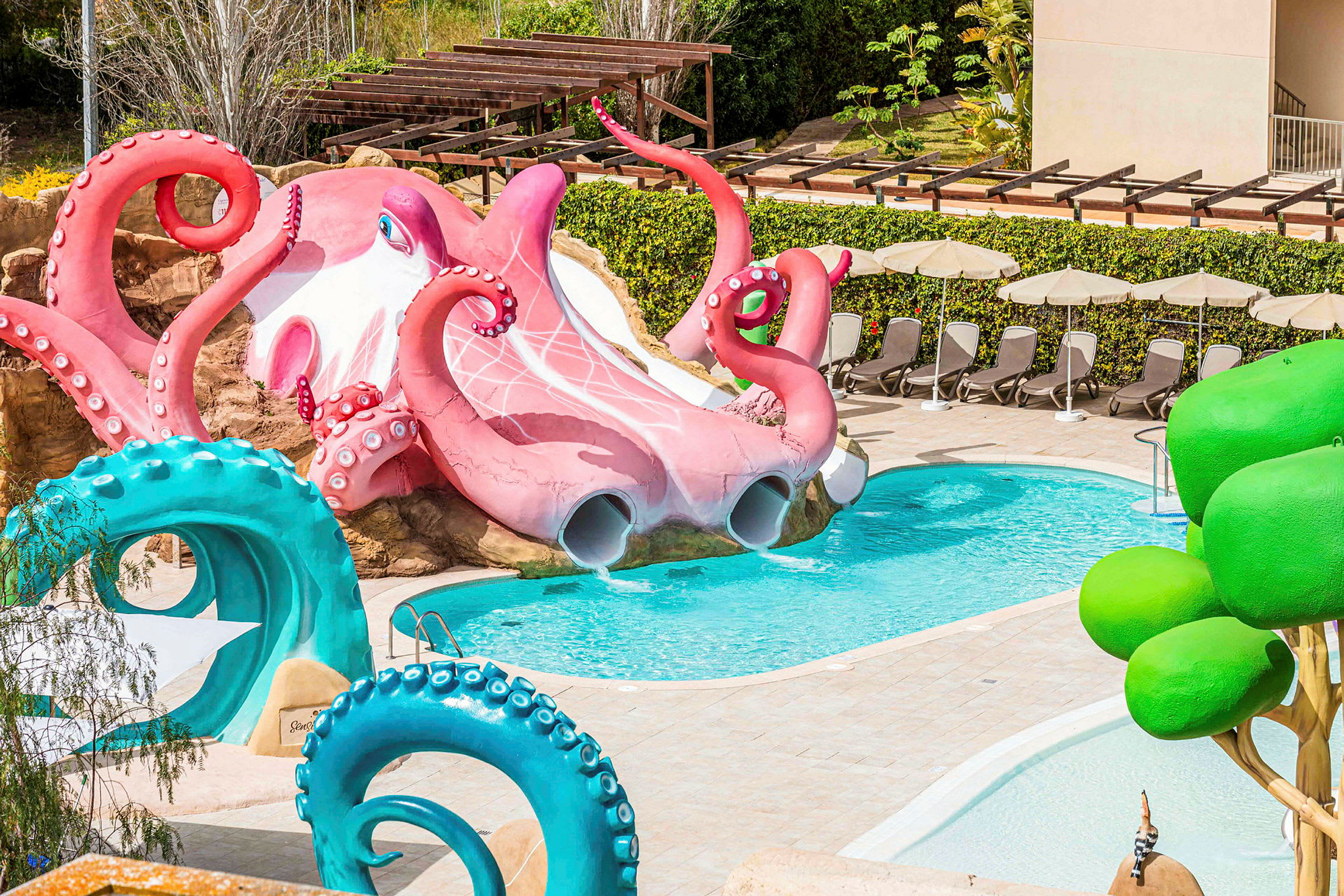 Vattentema med en stor rosa bläckfisk vid en pool, omgiven av solstolar och gröna detaljer. (AI-genererad text)
