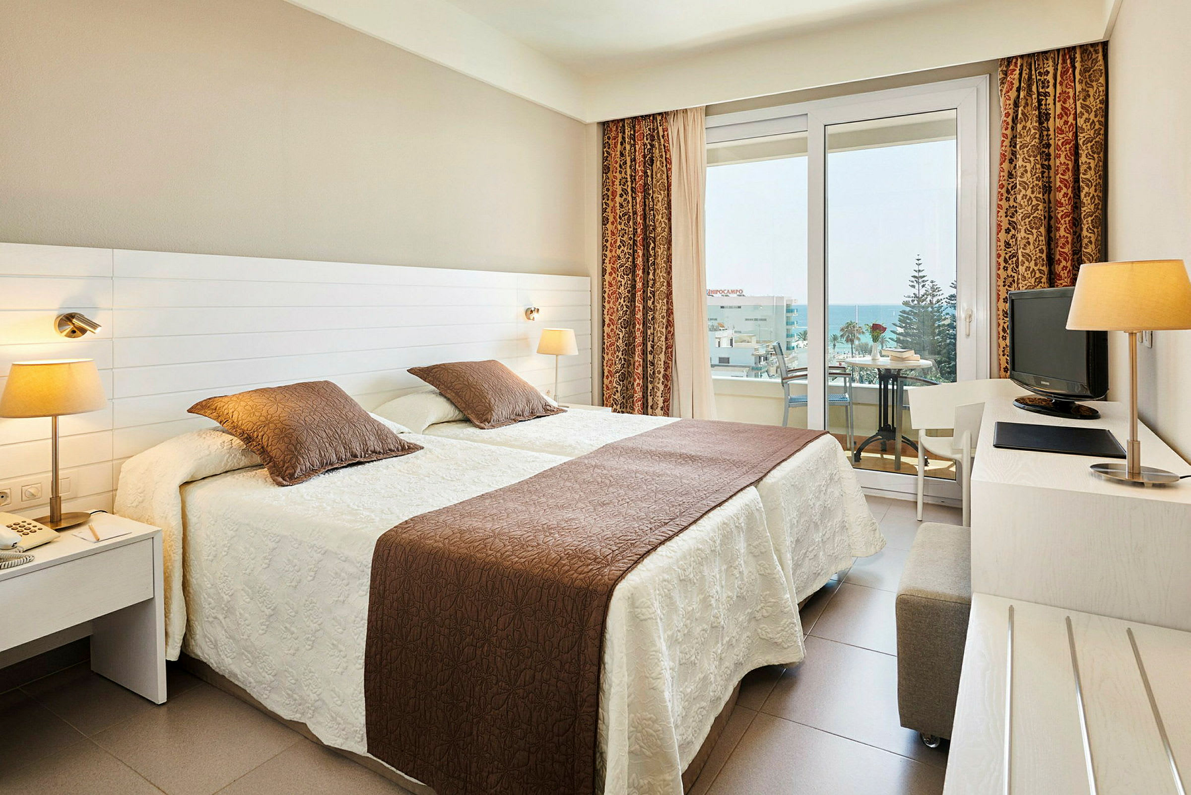 Hotellrum med två enkelsängar och balkong. (AI-genererad text)