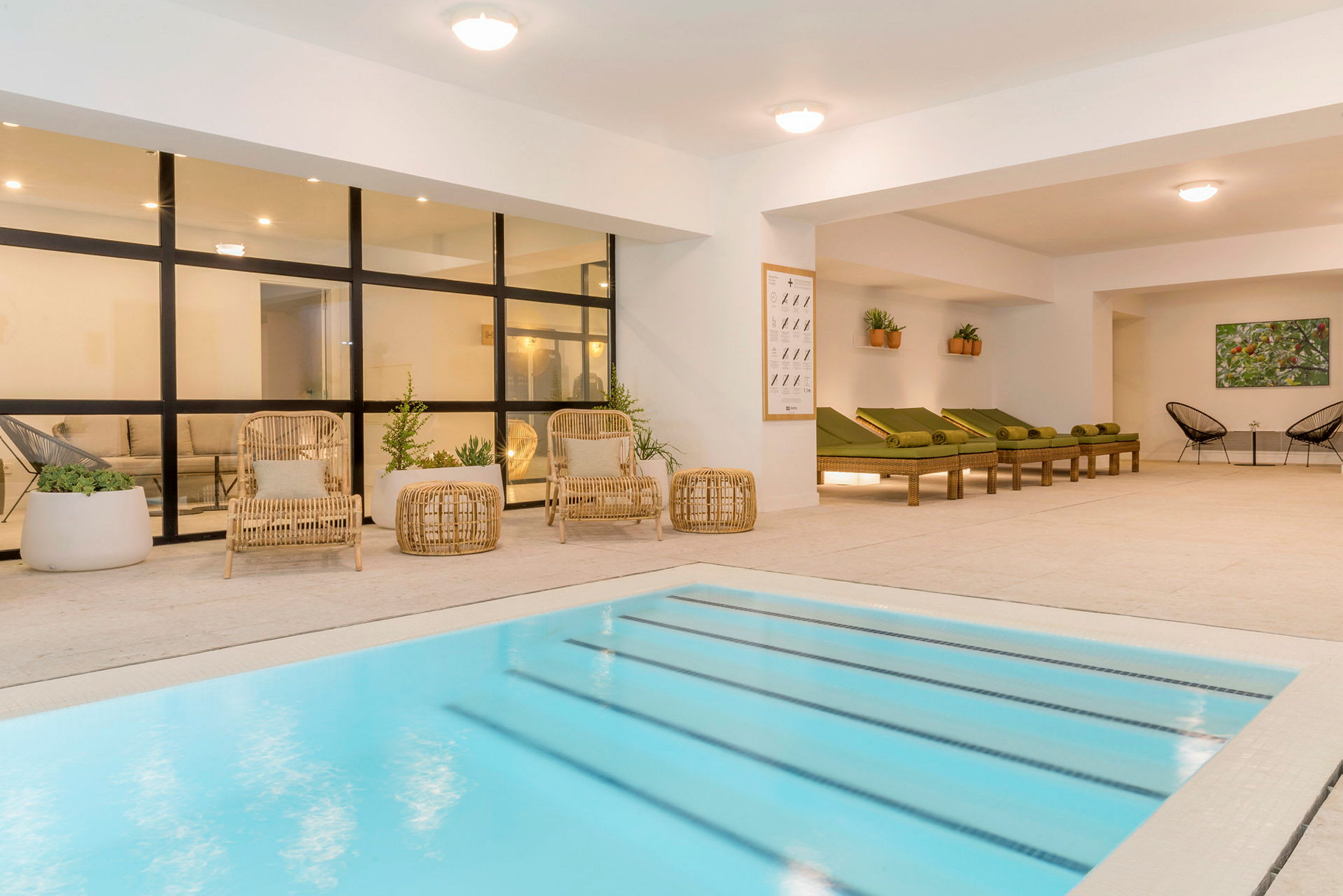 Modern interiör med pool och vilstolar bredvid. (AI-genererad text)