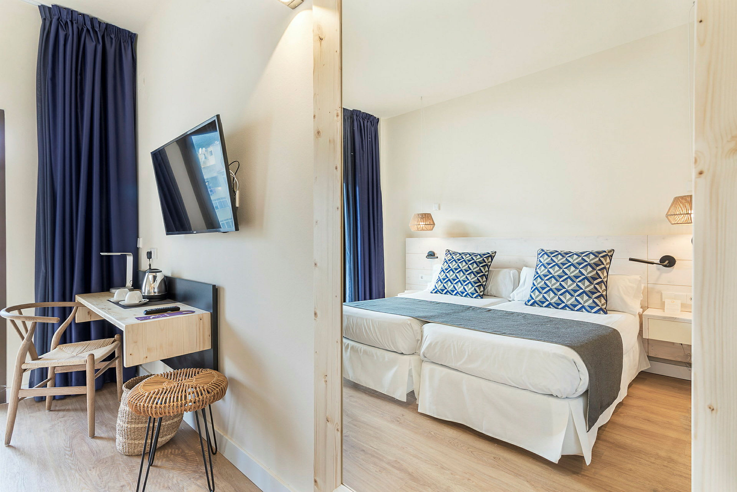 Hotellrum med två enkelsängar, skrivbord och TV. (AI-genererad text)