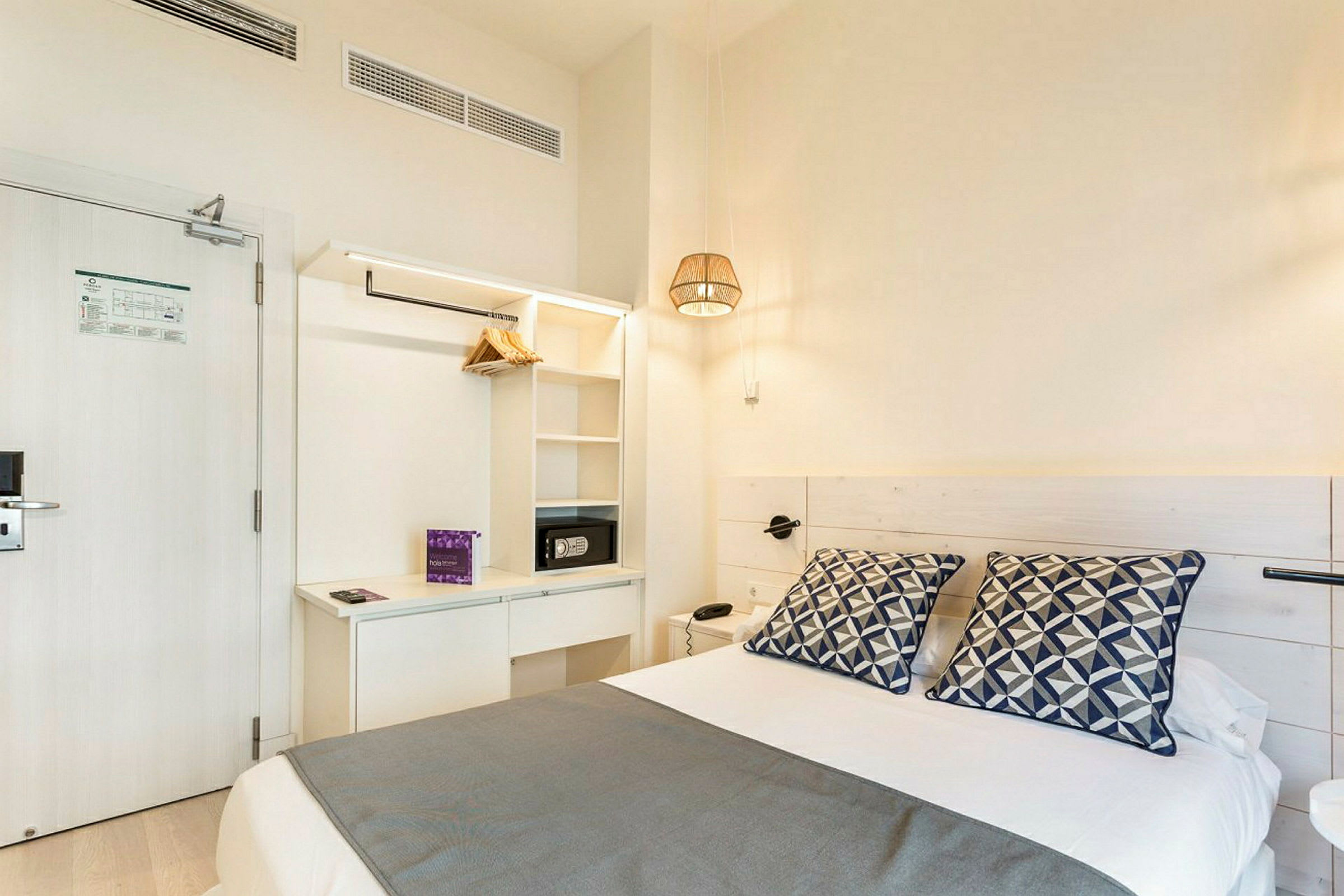 Hotellrum med en säng, lakan, prydnadskuddar och förvaring. (AI-genererad text)