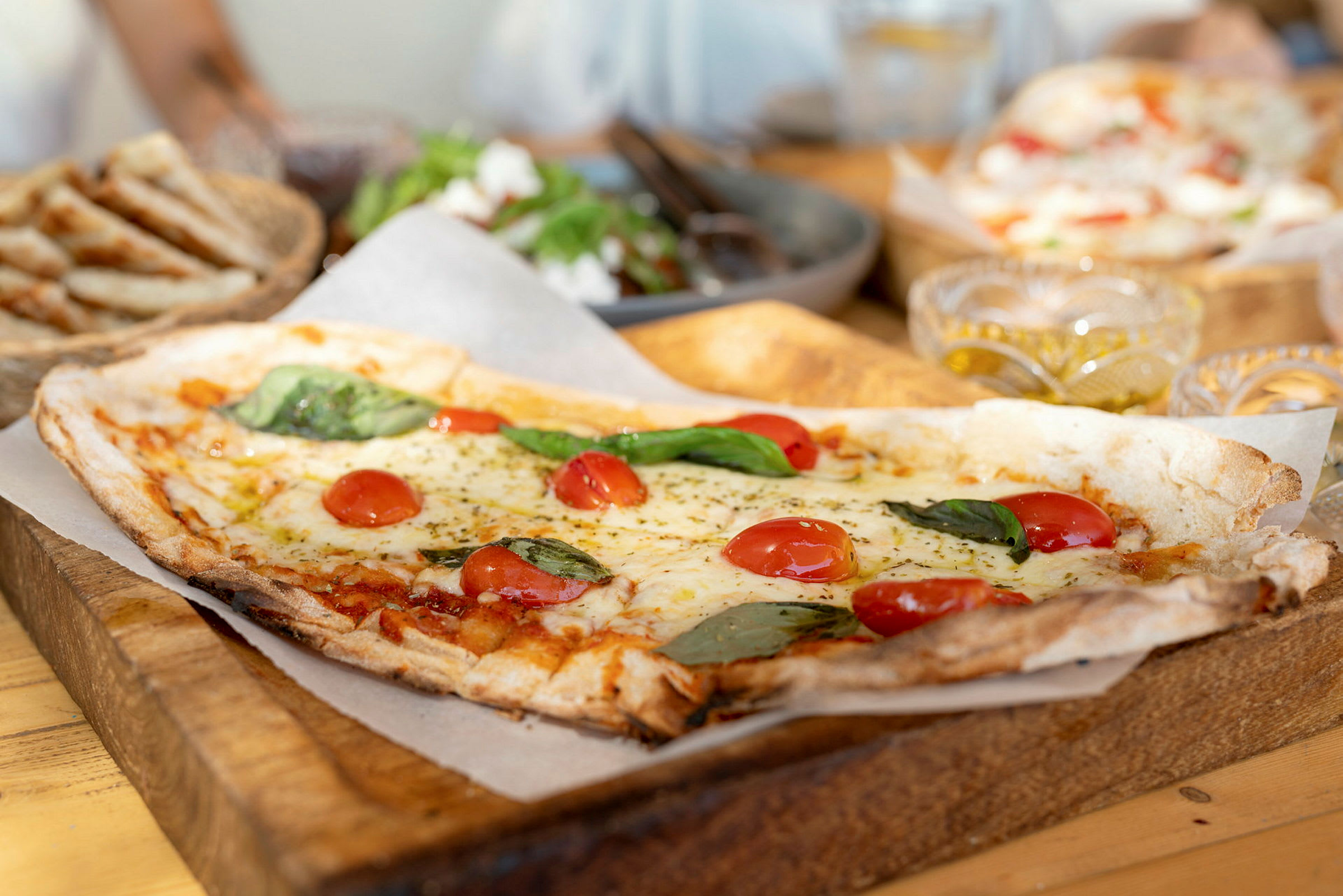Fyrkantig pizza med tomater och basilika på träskärbräda. (AI-genererad text)