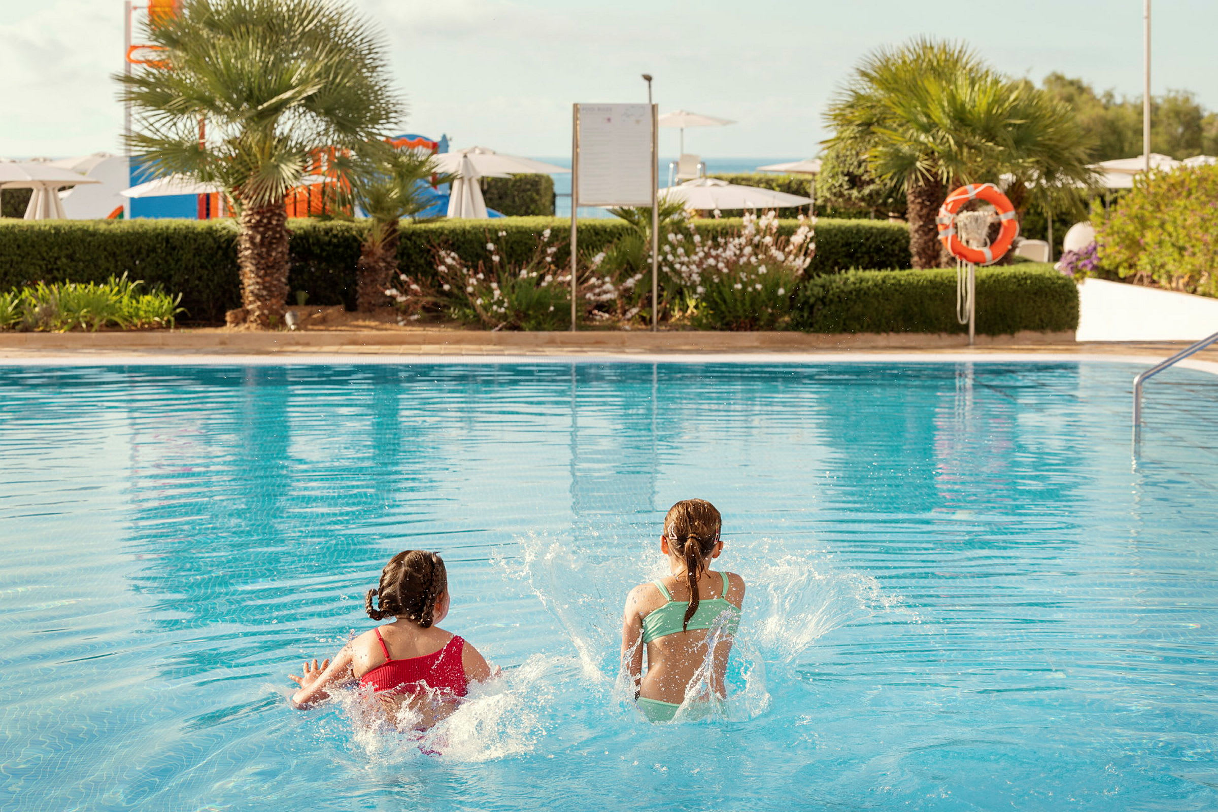 Två barn leker i en swimmingpool. (AI-genererad text)