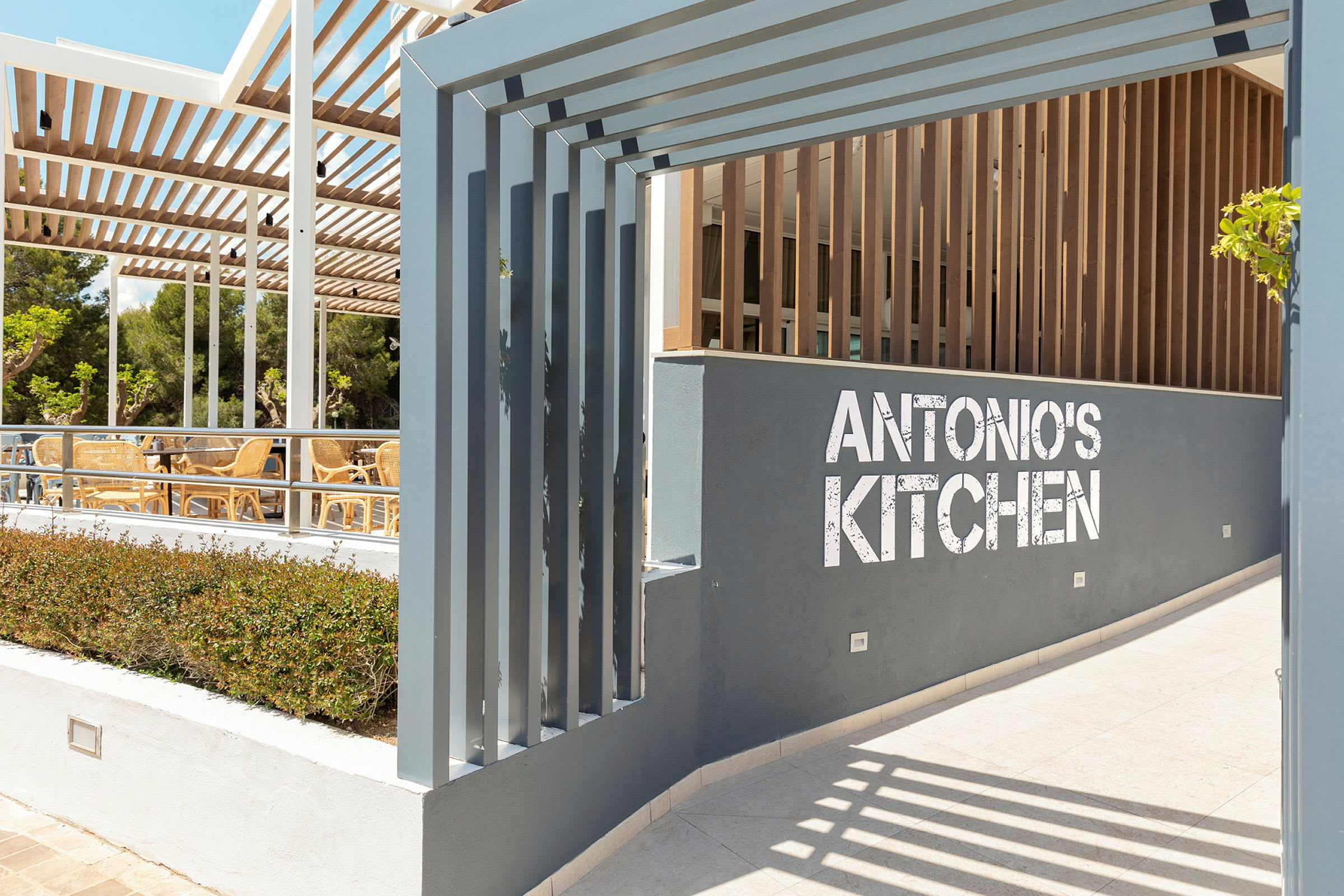 Ingång till restaurangen Antonio's Kitchen med sittplatser utomhus. (AI-genererad text)