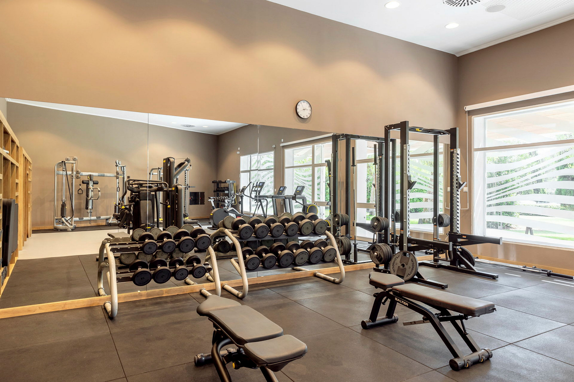 Bild av ett gym med olika träningsmaskiner och fria vikter. (AI-genererad text)