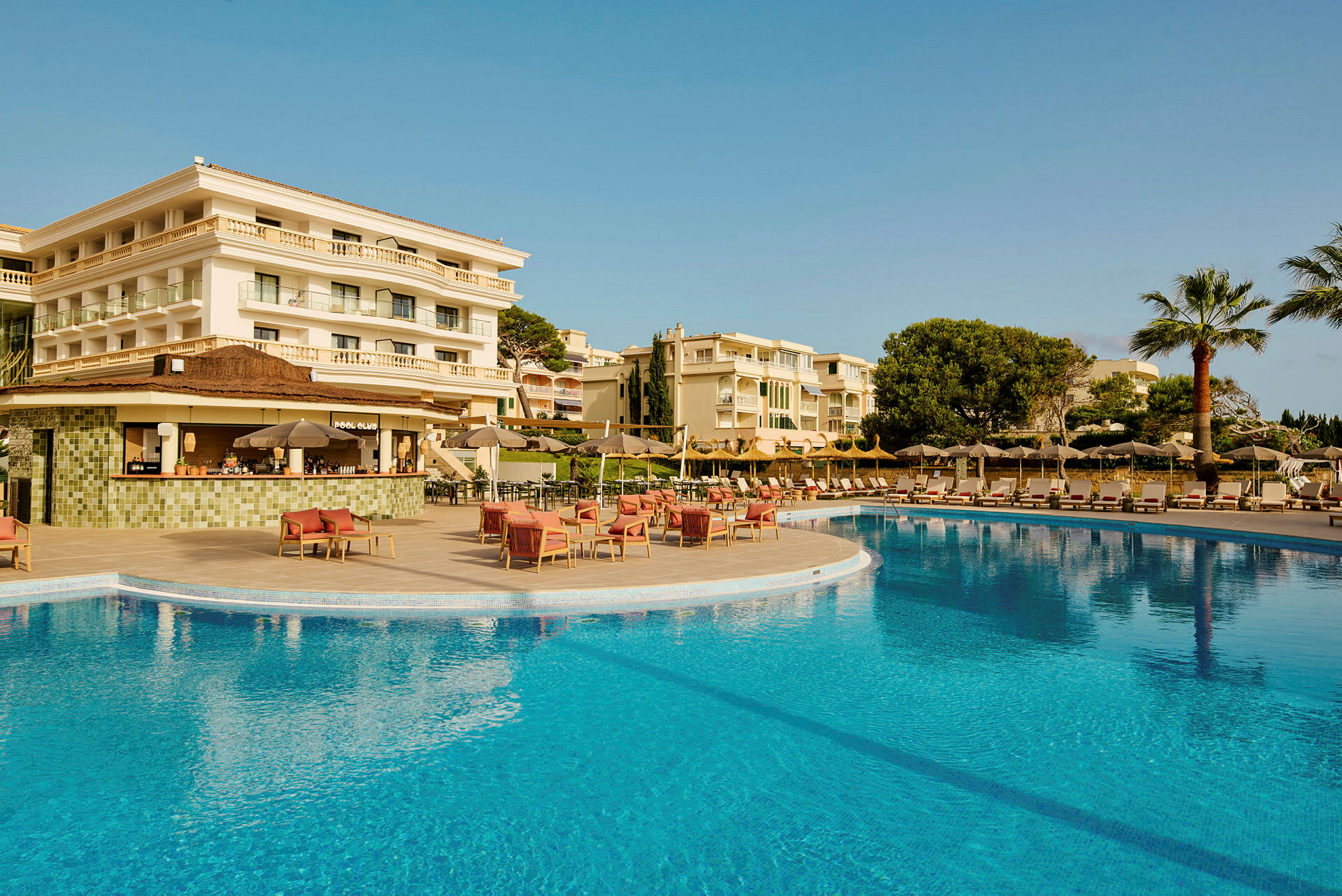 Bild av en hotellbyggnad, en pool och sittgrupper. (AI-genererad text)