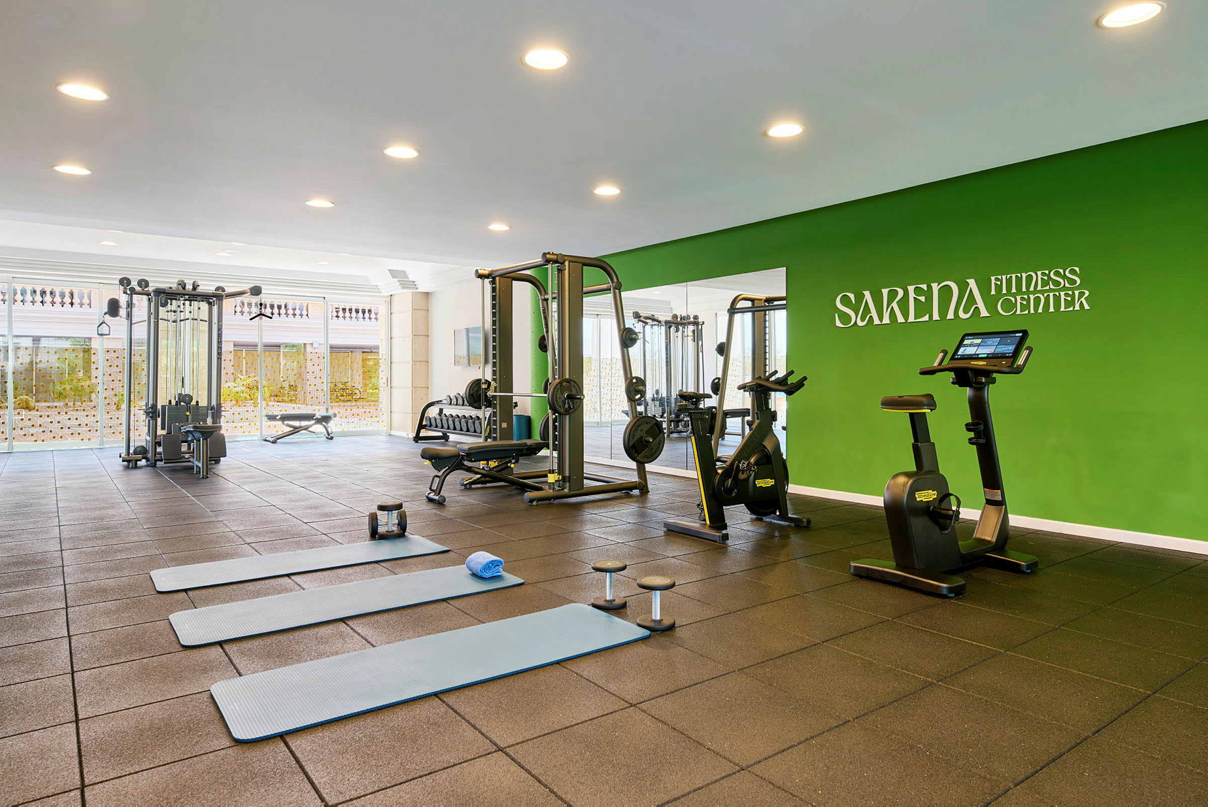 Ett gym med olika träningsutrustningar och grönt tema. (AI-genererad text)